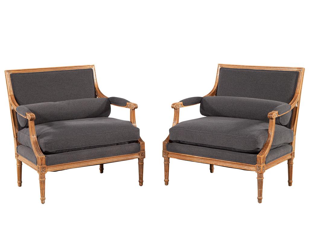 Pair of vintage Louis XVI bergère arm parlor chairs. Italy, circa 1950’s. Restored in a designer grey fabric with natural light walnut frames. Chairs include removable seat cushion and round bolster for support. Price includes complimentary curb
