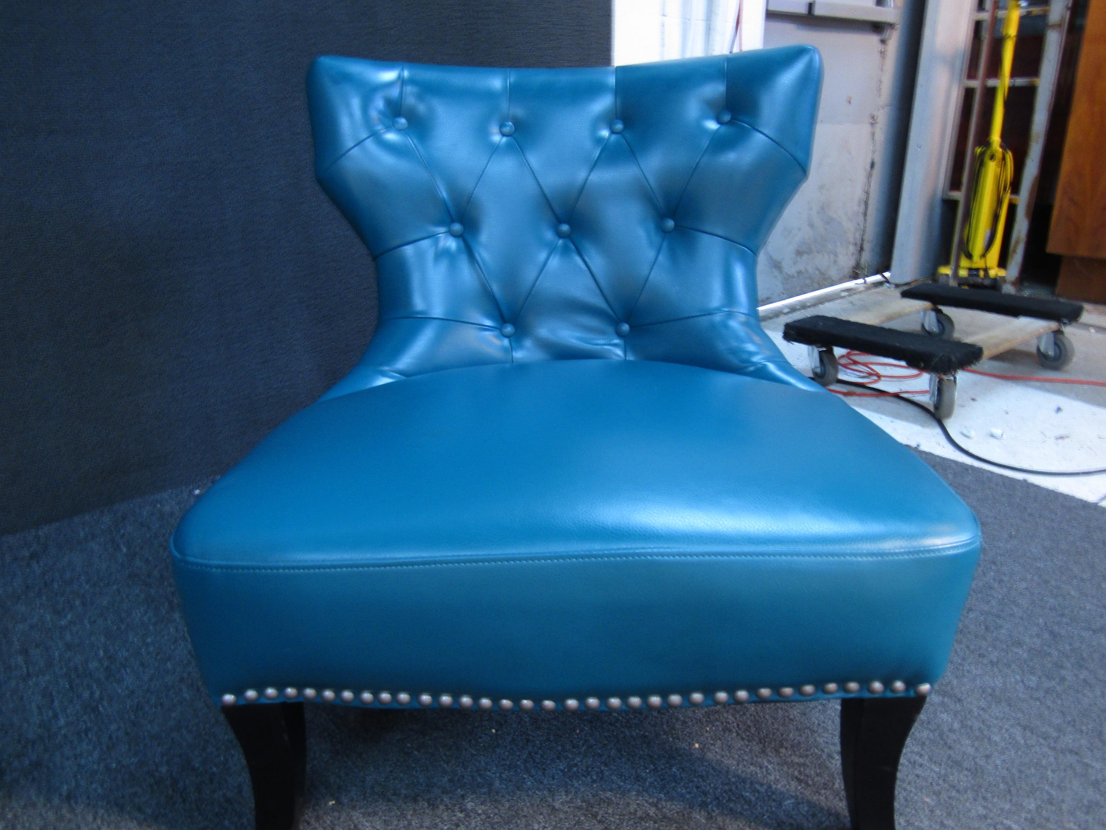 Upholstered in a brilliant blue material, this pair of vintage lounge chairs is a sure way to add comfort and a pop of color to any space. Please confirm item location with seller (NY/NJ).