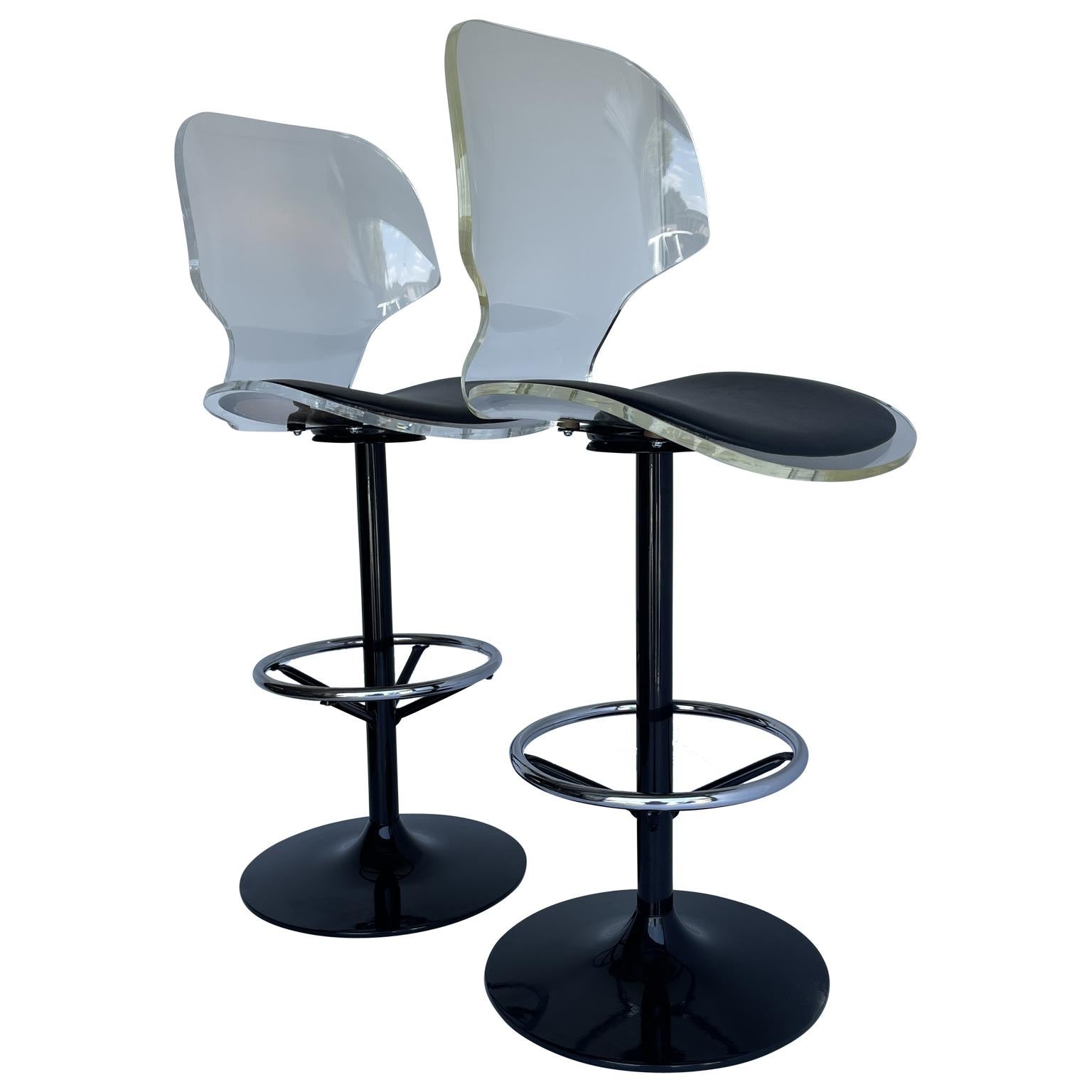 Set of two black-painted chrome and lucite swivel barstools. The chrome has been partially newly powder-coated and the seat are newly upholstered in black vinyl.