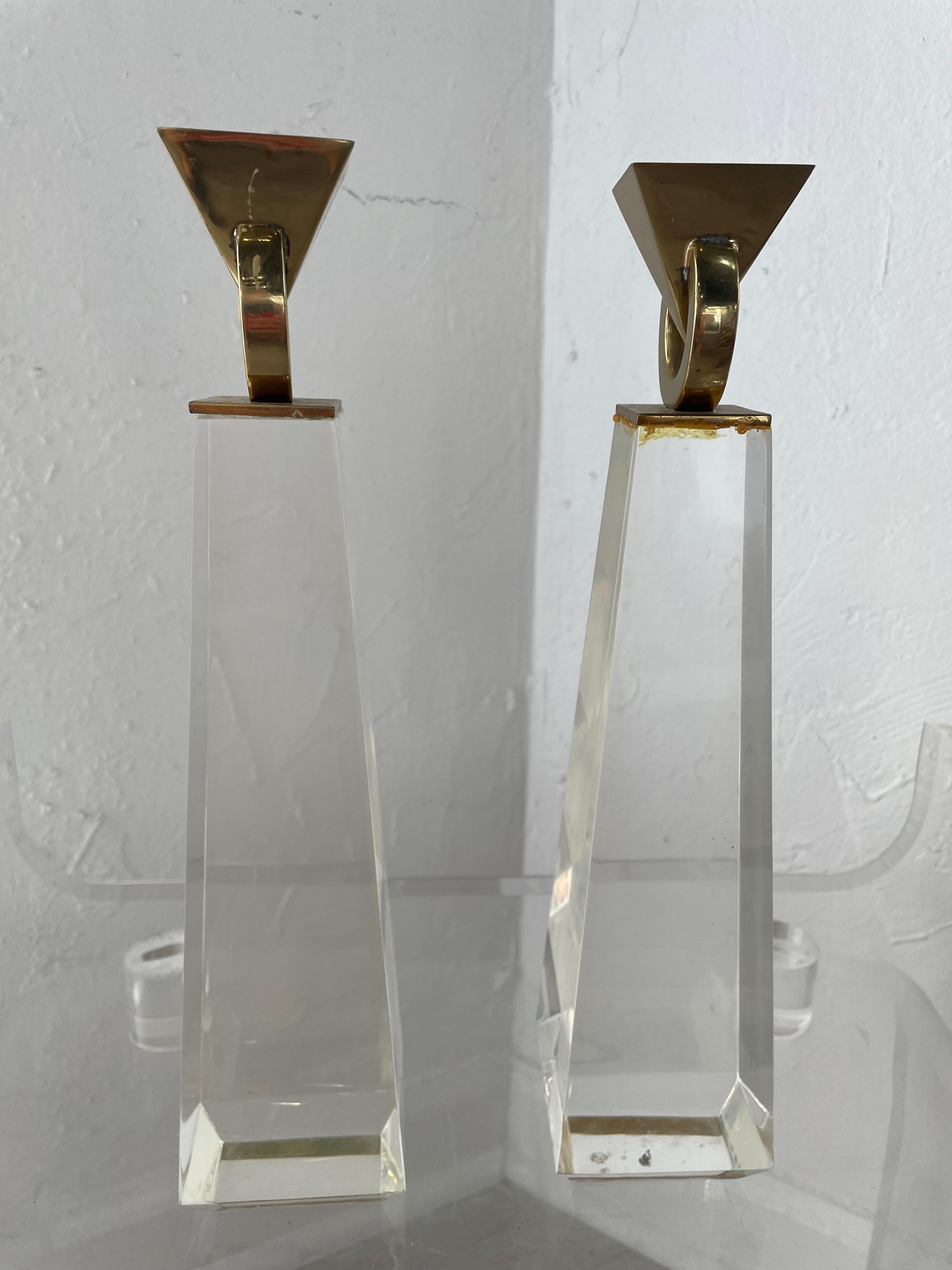 Paire de chandeliers en Lucite en forme d'obélisque avec un sommet géométrique moderne en laiton poli. Une combinaison qui fait une déclaration rétro.
