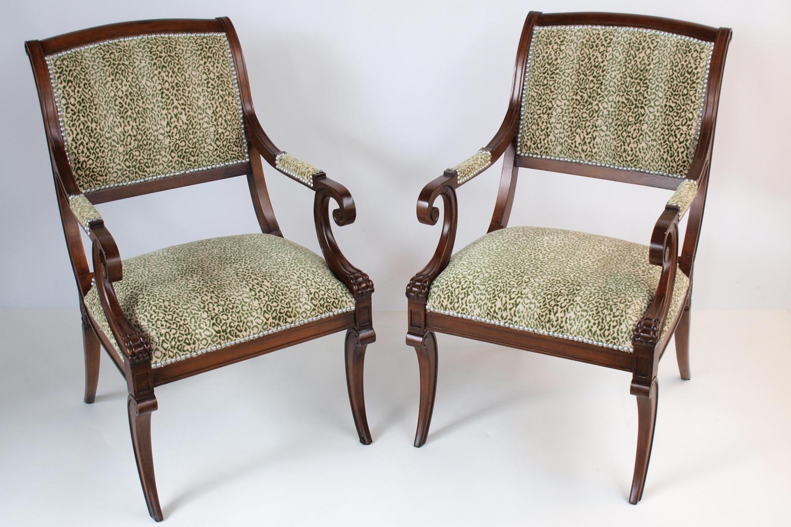 Pair of klismos-form armchairs, having solid mahogany frames with curved tablet form padded backrest, issuing scrolling arms, on downswept, paw-form terminals, its crown seat on the fielded apron, raised on square, tapering, sabre legs. Upholstered