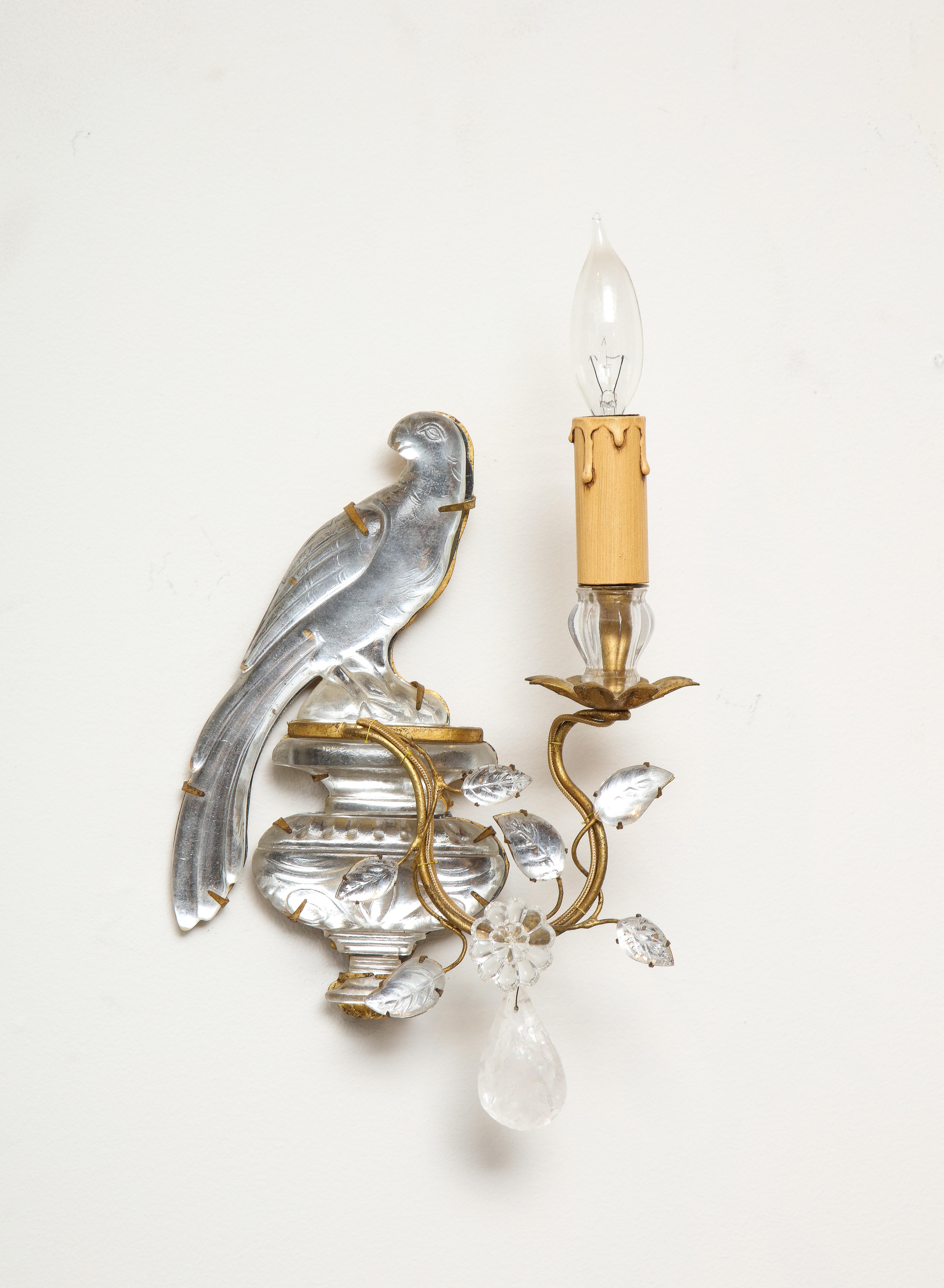 A wonderful pair of vintage Maison Baguès rock crystal bird form sconces. Two delicately carved birds sit atop decorated vases held in un obtrusive brass frames. Rock crystal pendants dangle from the tendril and three rock crystal leaves surround a