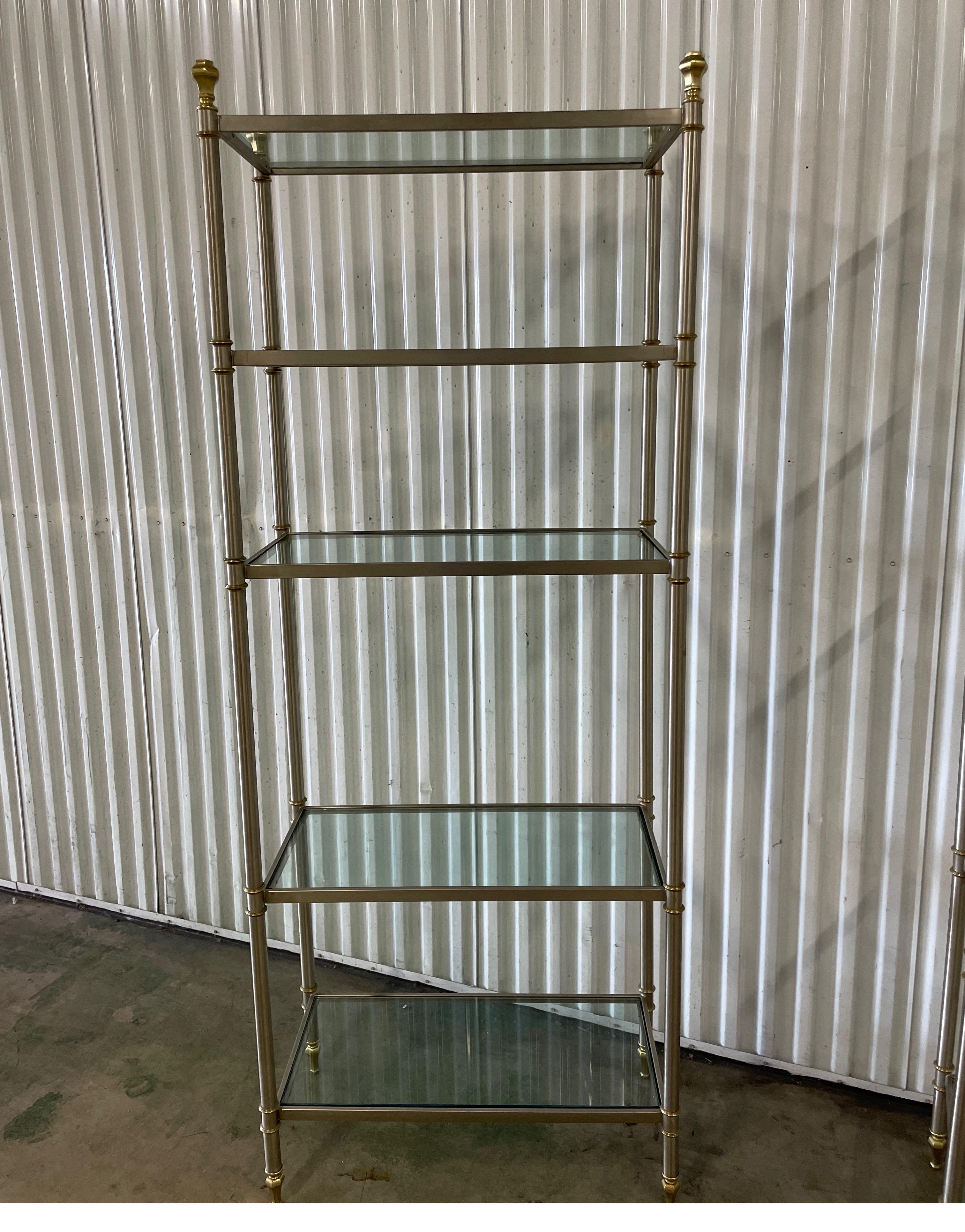 Pair of Vintage Maison Jansen Neoclassical style brushed steel and brass etageres with glass shelves. Each etagere has five shelves including top. 