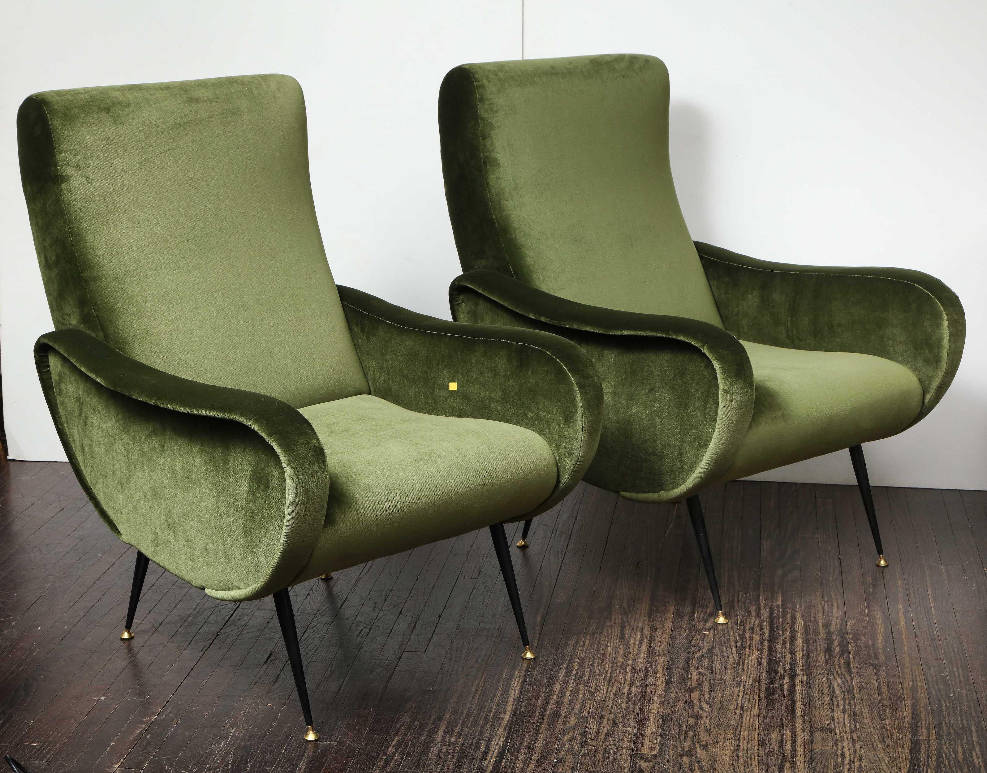 A beautiful pair of vintage green velvet armchairs in the style of Marco Zanuso. Elegant and sleek midcentury pieces with great comfort. They are newly upholstered and have original iron legs with brass caps.