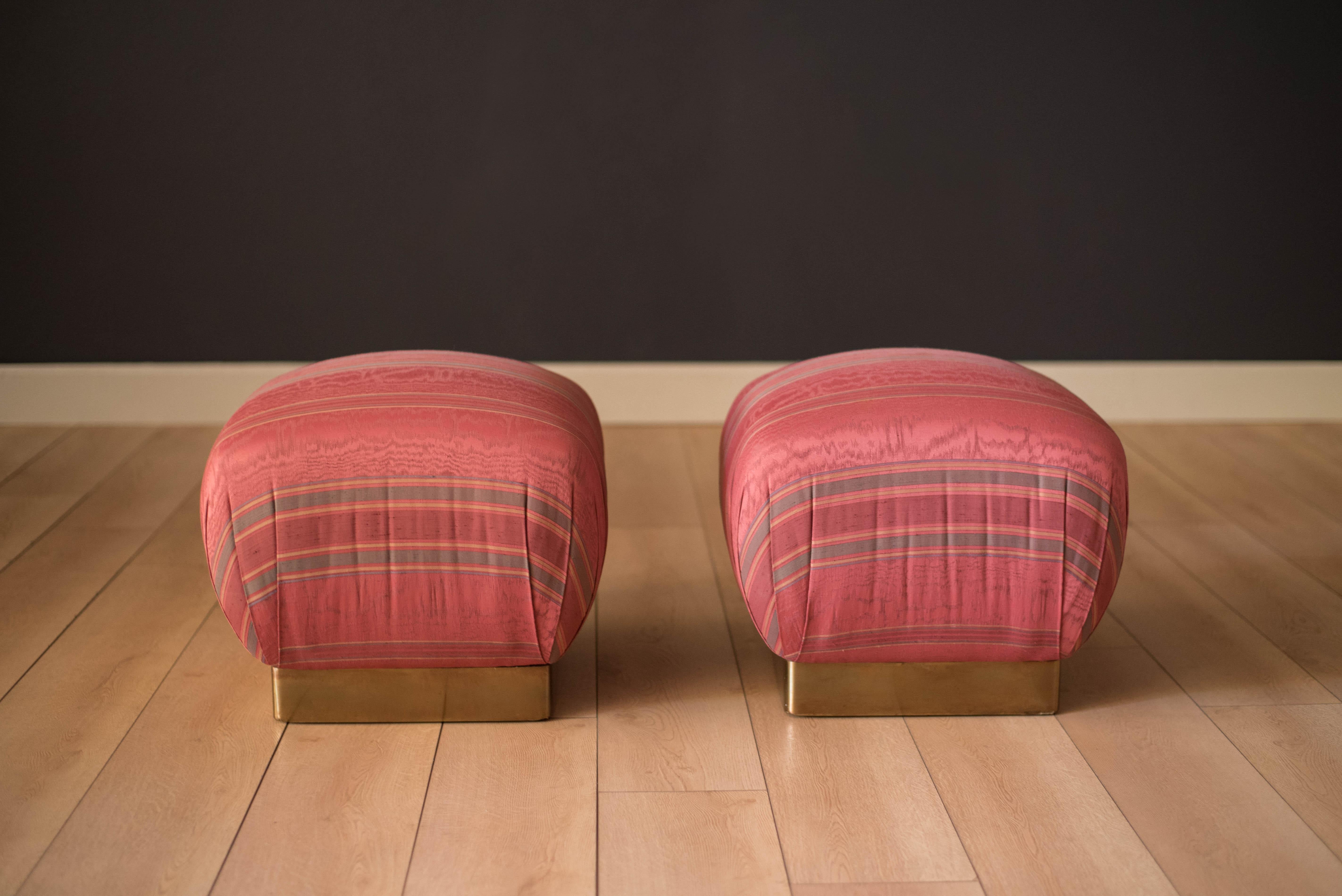 California modern designed pair of vintage lounge ottoman poufs by Marge Carson, circa 1970s. This inviting set provides a comfortable seat with a supportive firm cushion. The base is accented with brass trim that displays nicely aged patina. The