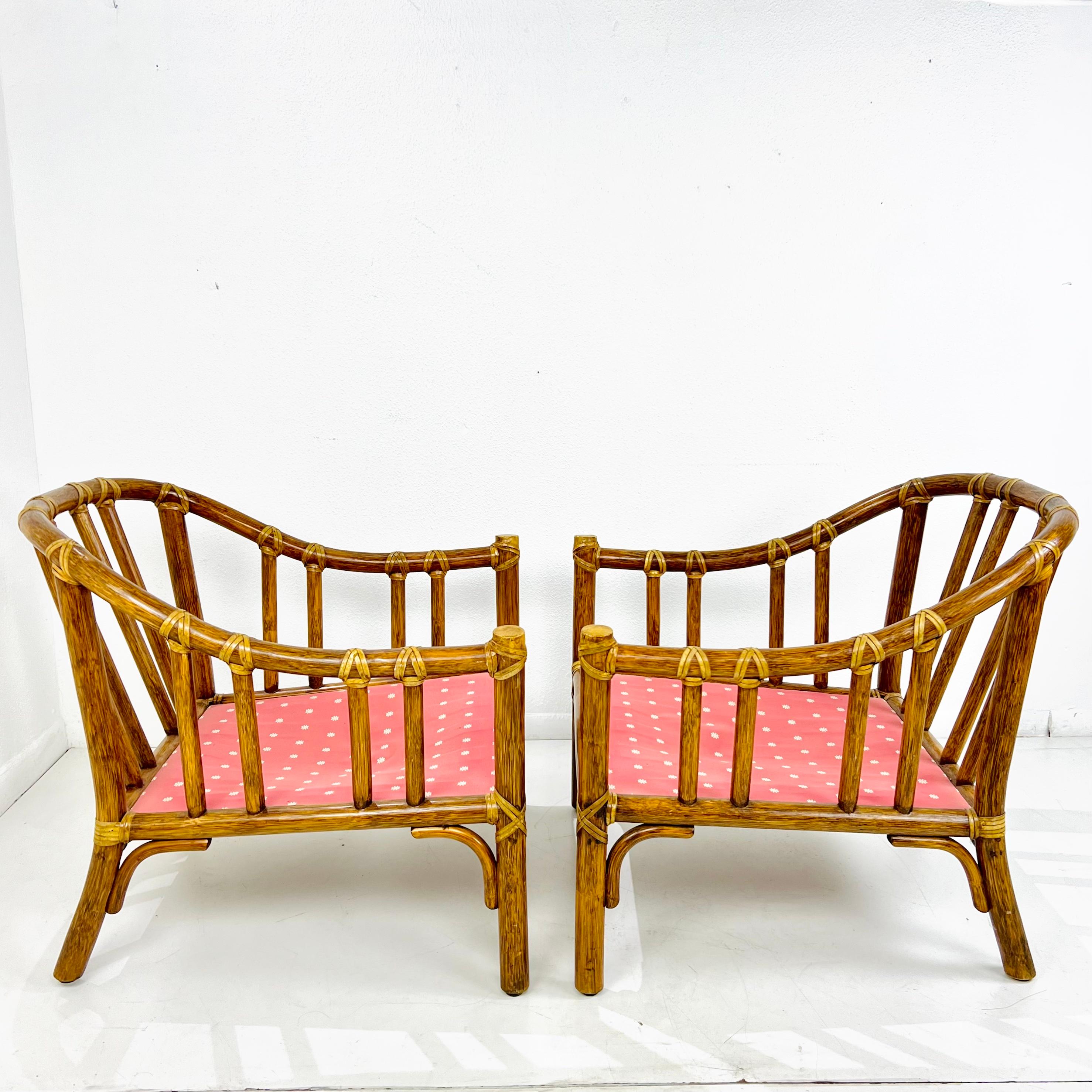 Fantastic vintage pair of McGuire of San Francisco armchairs, featuring thick, bent pole rattan frames with gracefully curved backs. The rattan is lashed together with leather rawhide laces. Frame and lacing in excellent condition. Does not include