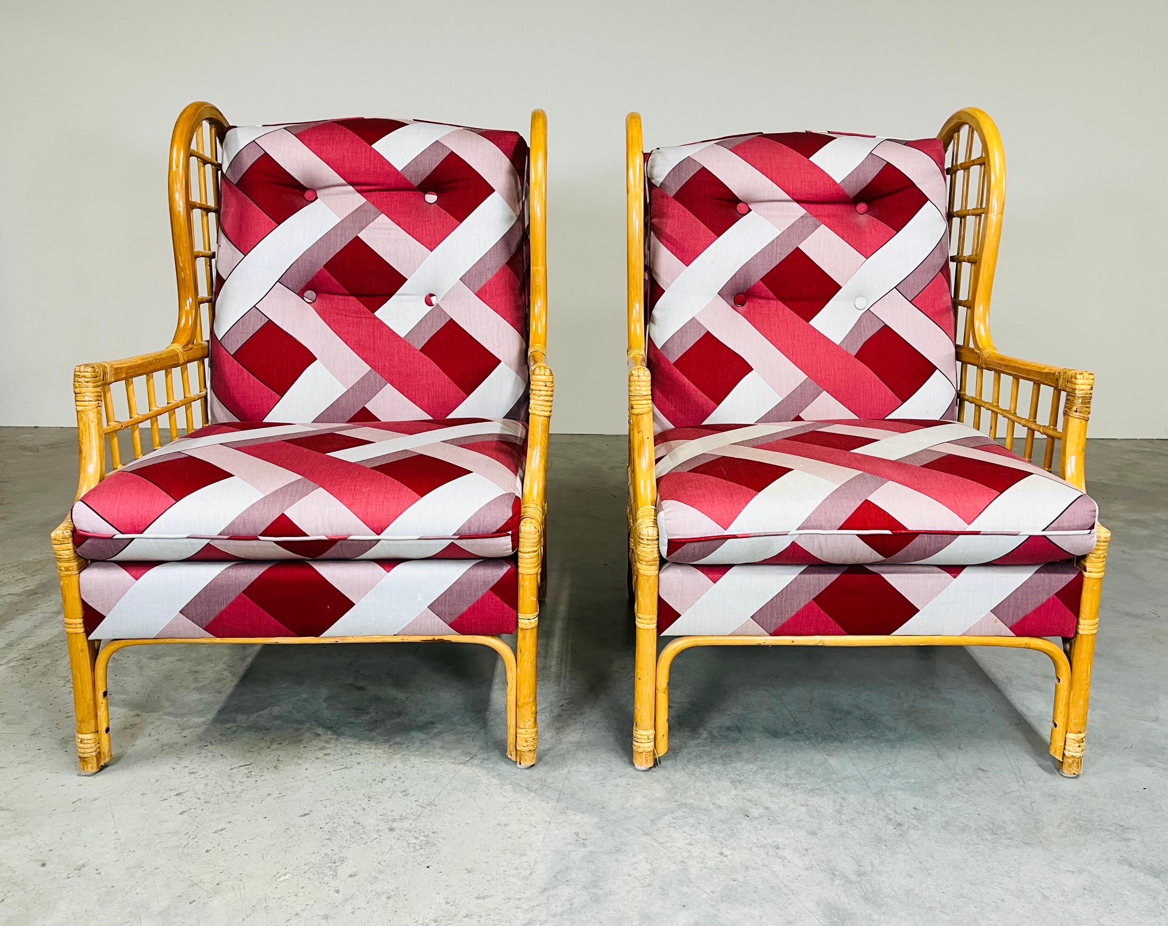 Vintage Mcguire style rattan wingback style arm chairs featuring wrapped rattan lattice patterned sides and back with soft backrests and seat cushions. Incredibly comfortable. In excellent vintage condition having sturdy frames that feature strong