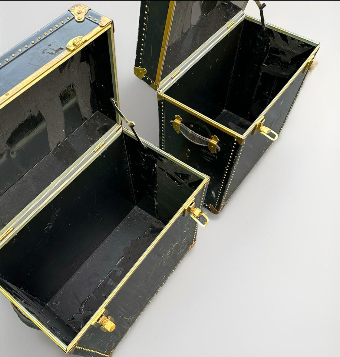 Pareja de baúles de equipaje de campaña de cuero Meek's vintage. Estas mesas de almacenaje son de color negro, tienen una altura de 22,5 pulgadas y se pueden utilizar como mesas auxiliares o mesillas de noche. Son de madera y cuero, con un estilo de