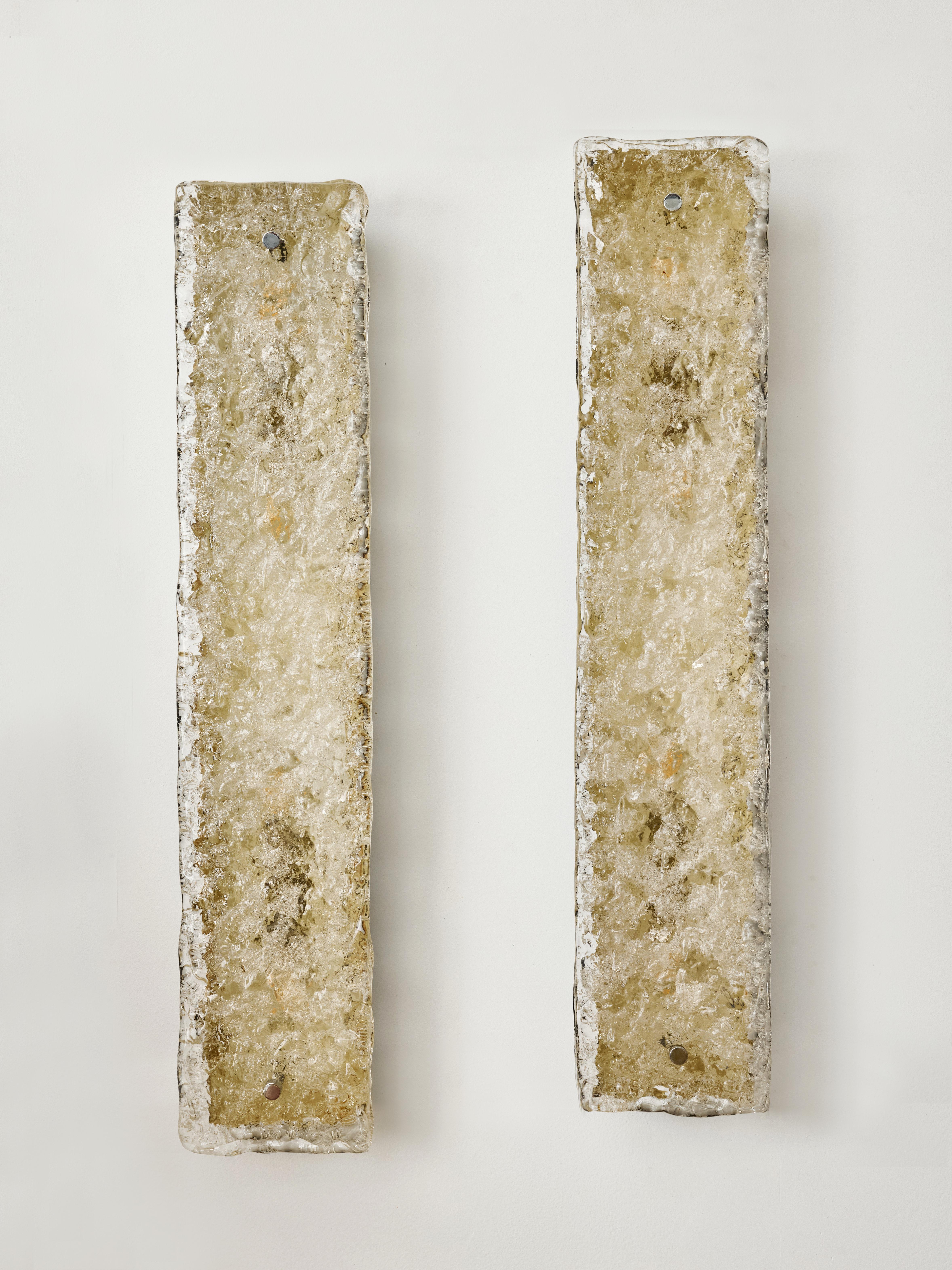 A pair of vintage wall sconces featuring a metal frame with a white interior designed to enhance the illumination from the four internal light sources. The structure is covered with a molded glass panel, which texture diffuse the light while hiding