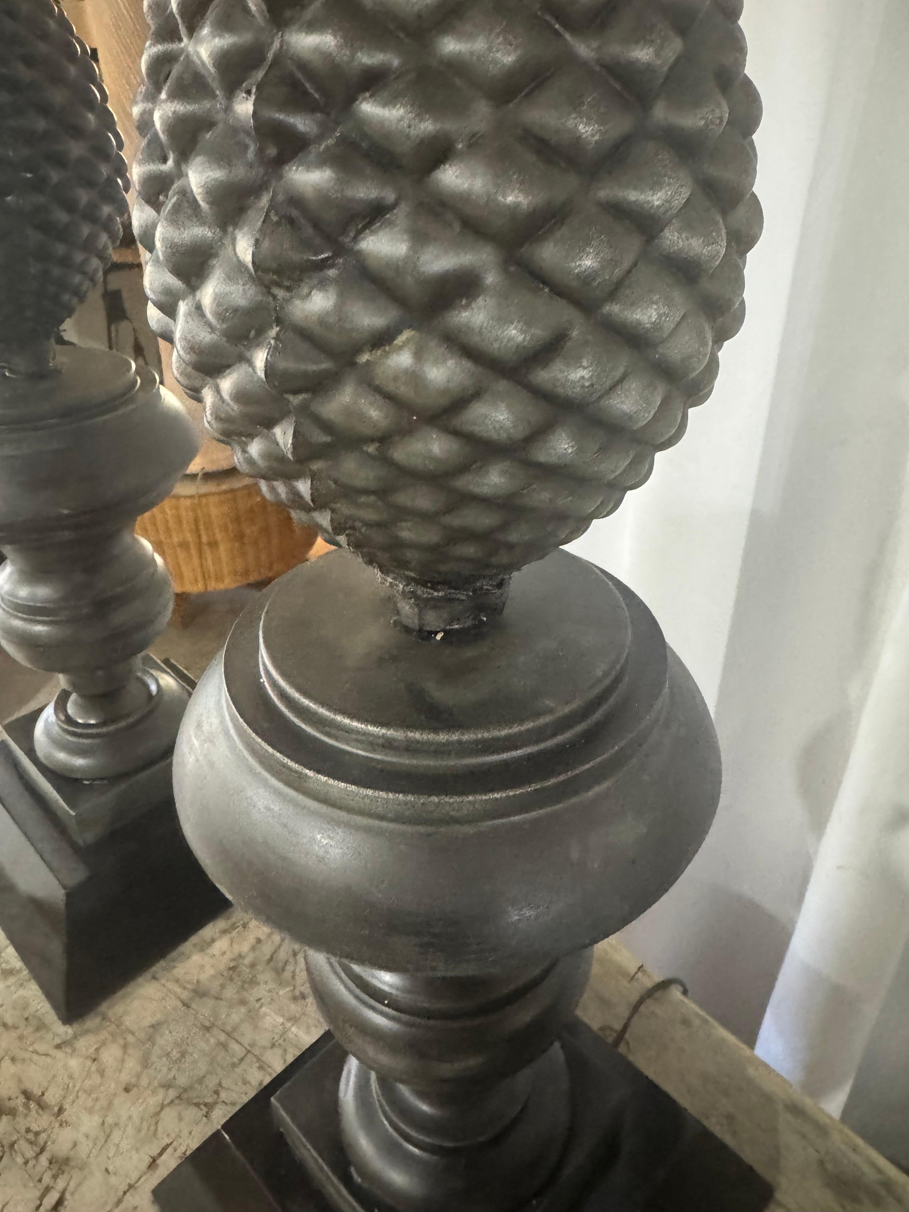 Cette paire de lampes de table ananas en métal vintage, magnifiquement restaurée, dégage un charme néoclassique avec un design sculptural saisissant. Ces lampes sont dotées d'un motif d'ananas en zinc moulé très détaillé, symbolisant l'hospitalité