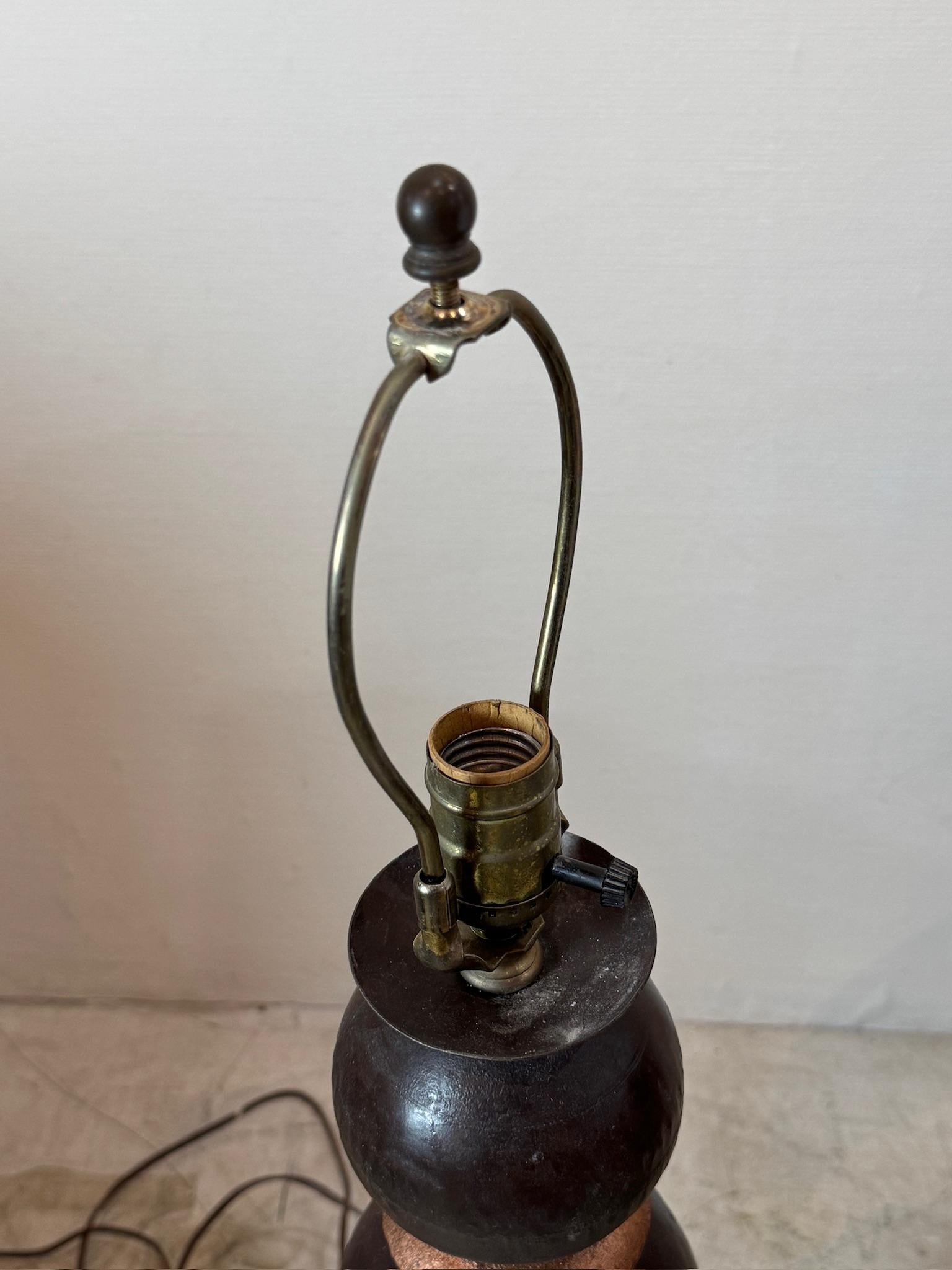 Dieses auffällige Paar Vintage-Tischlampen aus Metall mit dem raffinierten Design der gestapelten Kugeln wertet Ihren Raum auf. Der dunkle Metallsockel, der mit warmen kupferfarbenen Abstandshaltern akzentuiert ist, sorgt für einen kühnen, aber