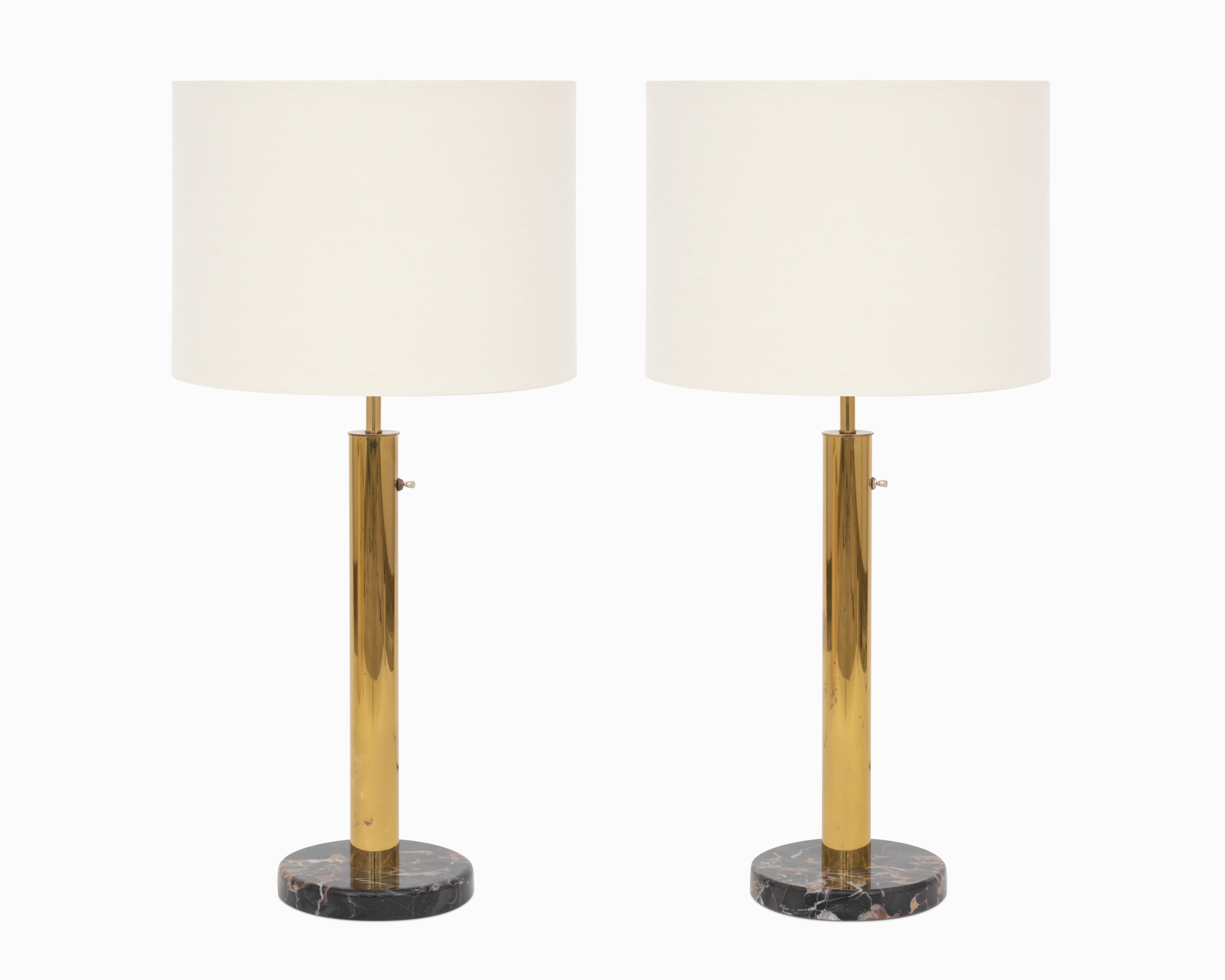 Voici une fabuleuse paire de lampes de table du milieu du siècle par NESSEN LIGHTING.  Les lampes hautes et minimalistes sont dotées de magnifiques bases en marbre noir et de corps élancés en laiton.  Ils sont en bon état d'origine et fonctionnent