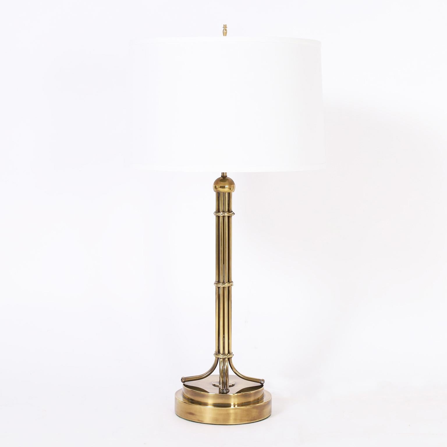 Chic pair of mid-century table lamps crafted in brass in a modern regency form with a hip burnished and lacquered finish.