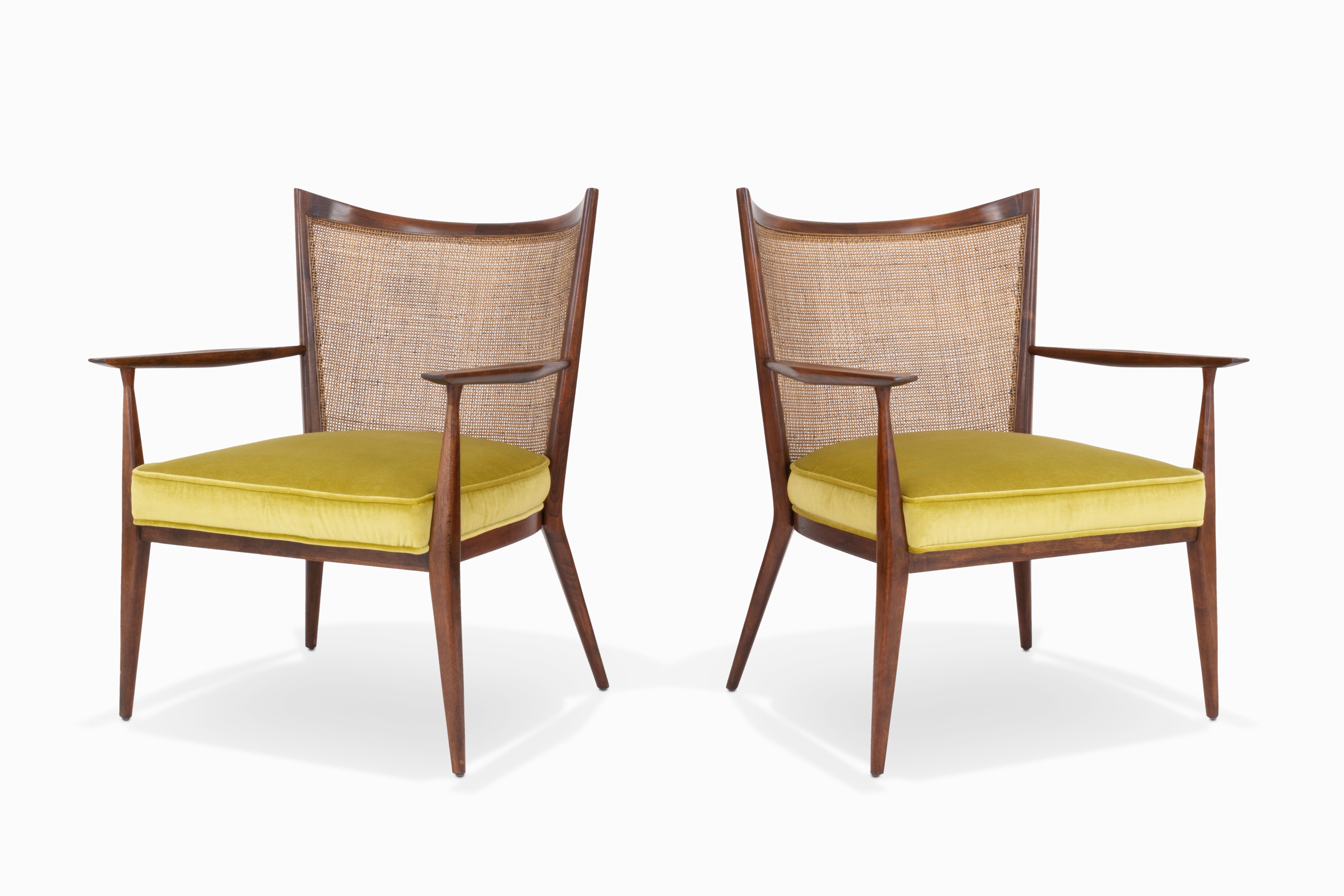 Here is a gorgeous pair of cane back lounge chairs designed by Paul McCobb for Directional. The frames and caning are in original condition accompanied by newly upholstered seat cushions in a lovely chartreuse velvet. These beautiful chairs feature