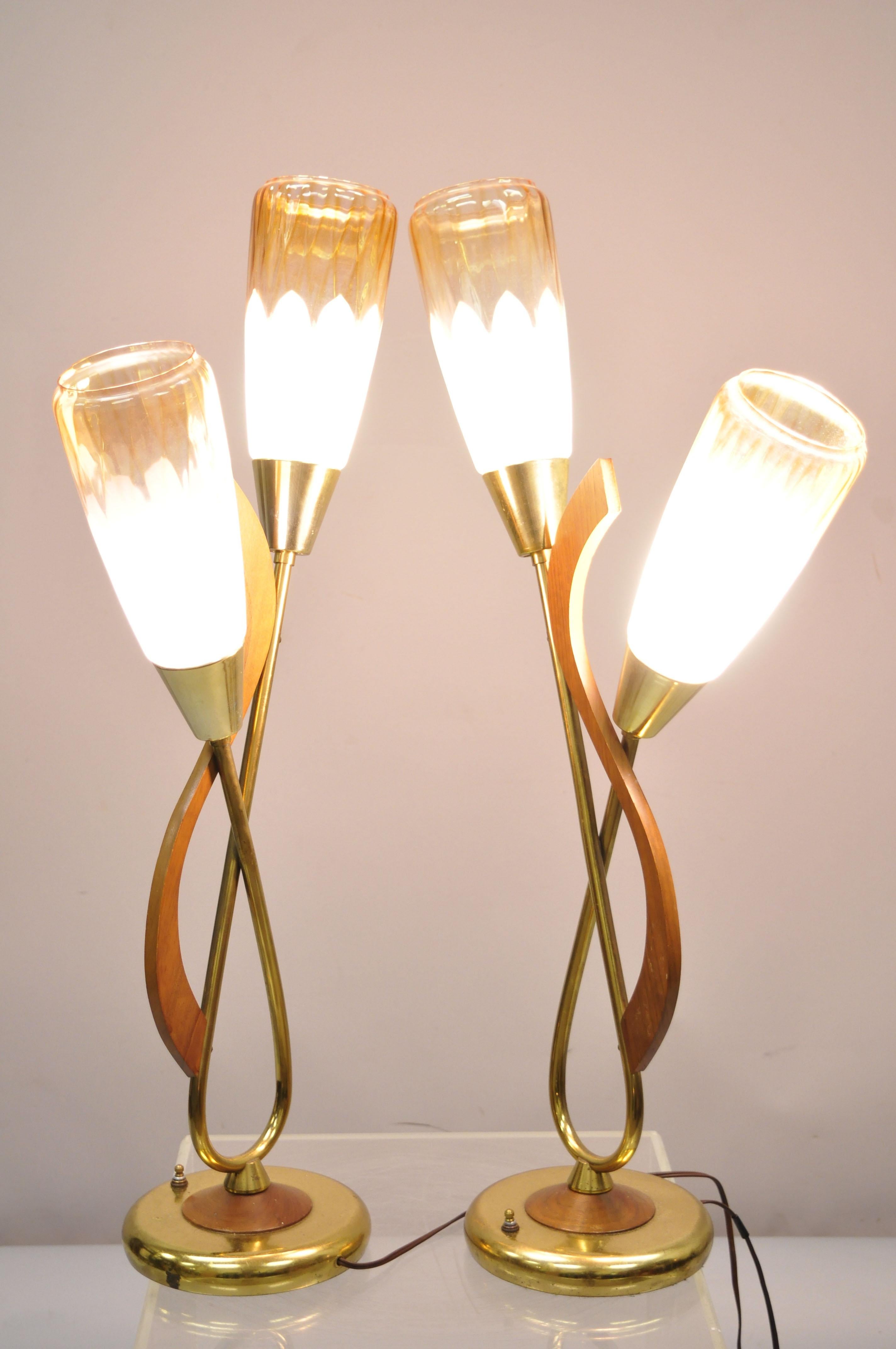 Pair of vintage midcentury Danish modern teak & brass atomic era table lamps. Item features beautiful glass shades, teak wood and brass accents, 3 way light functions, sleek sculptural form, circa mid-20th century. Measurements: 30
