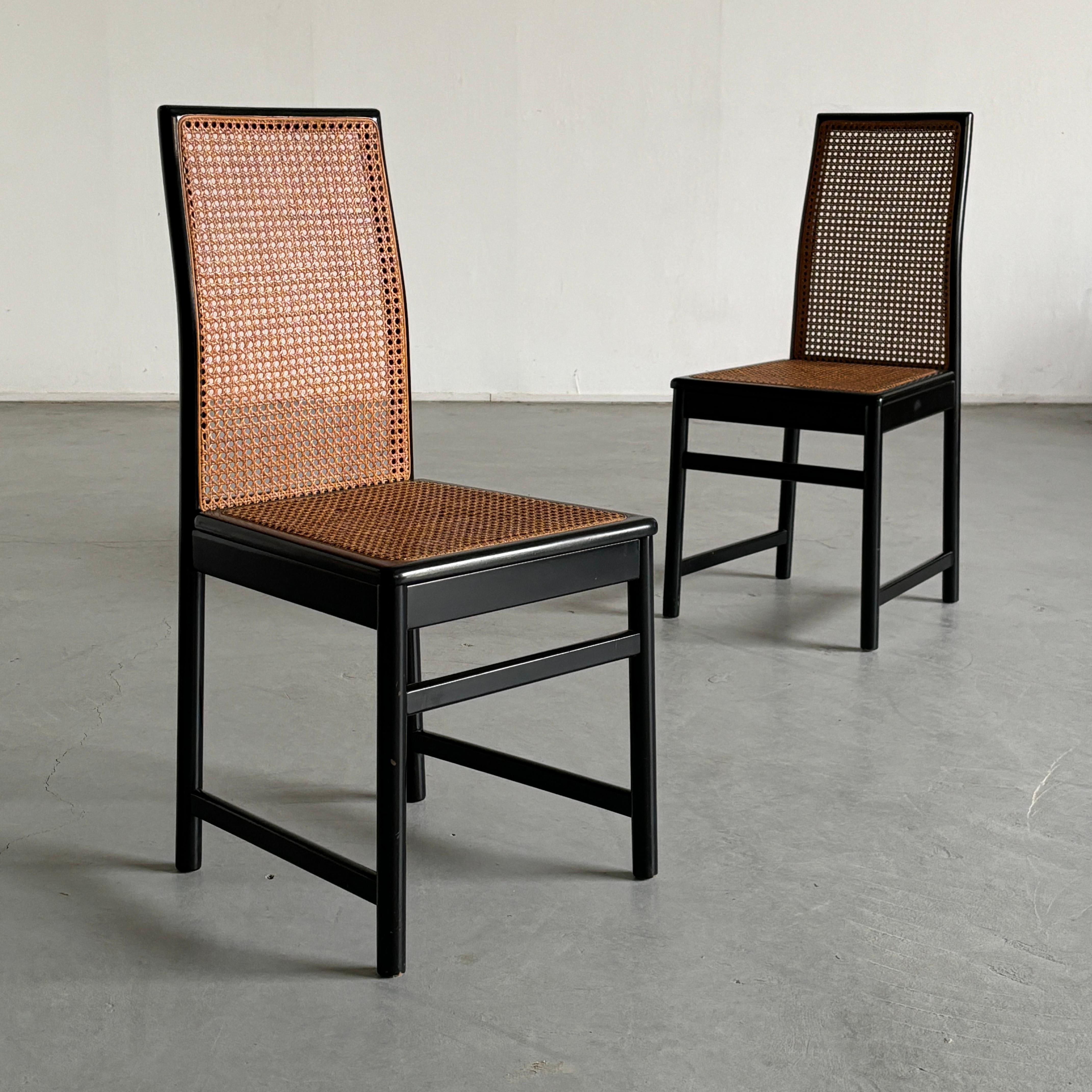 Pair of elegant, high-backrest dining chairs in black lacquered wood with rattan woven seats and backrests.

Price is for the pair.

Overall well preserved and in good vintage condition with minimal expected signs of age, as indicated in the photos.