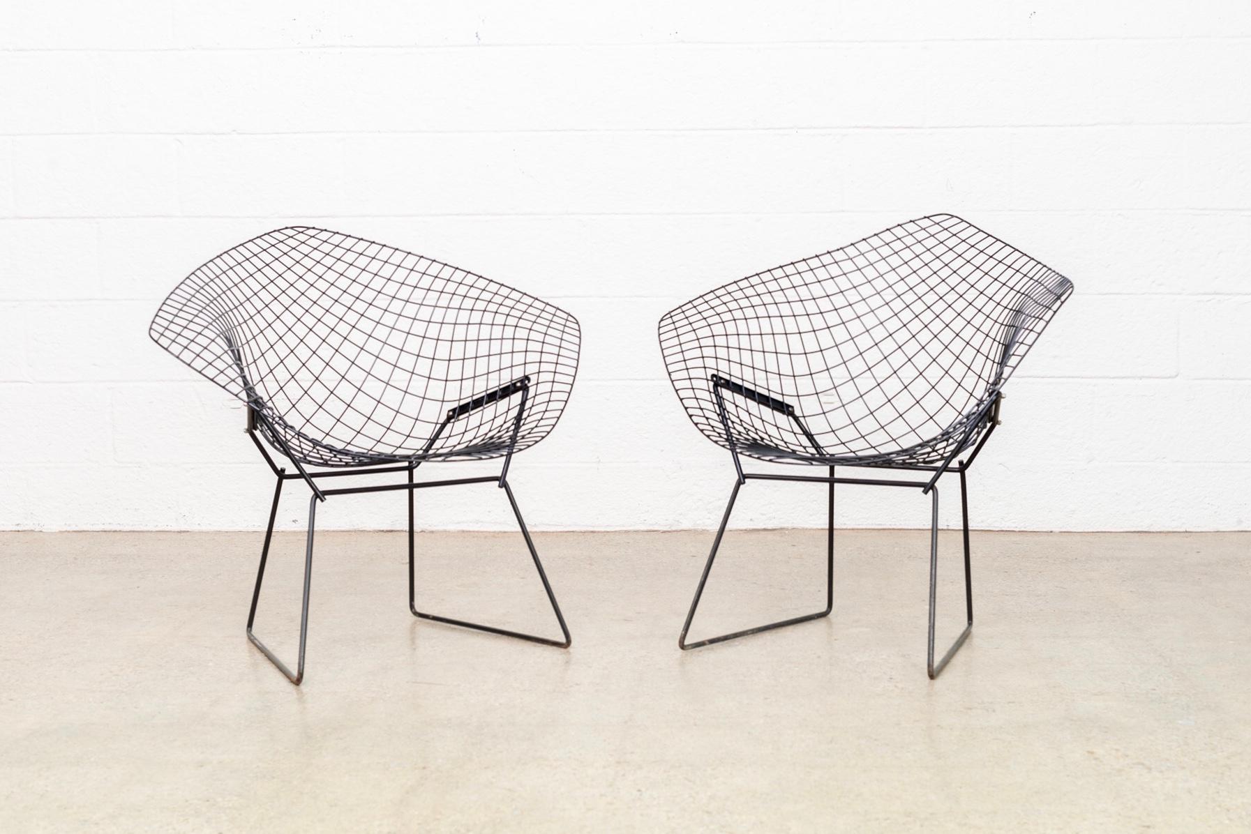 The diamond wire chair was designed by Harry Bertoia for Knoll in 1952. This pair of chairs features welded steel rod construction with a black finish. The sculptural form of this iconic chair make it a fixture of Mid-Century Modern