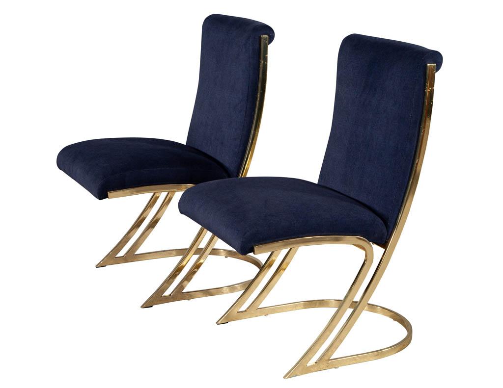 Pair of vintage Mid-Century Modern brass dining chairs. Solid mirror brass frames upholstered in a navy velvet. Brass frames are all original, wear consistent with age and use.

Price includes complimentary scheduled curb side delivery service to