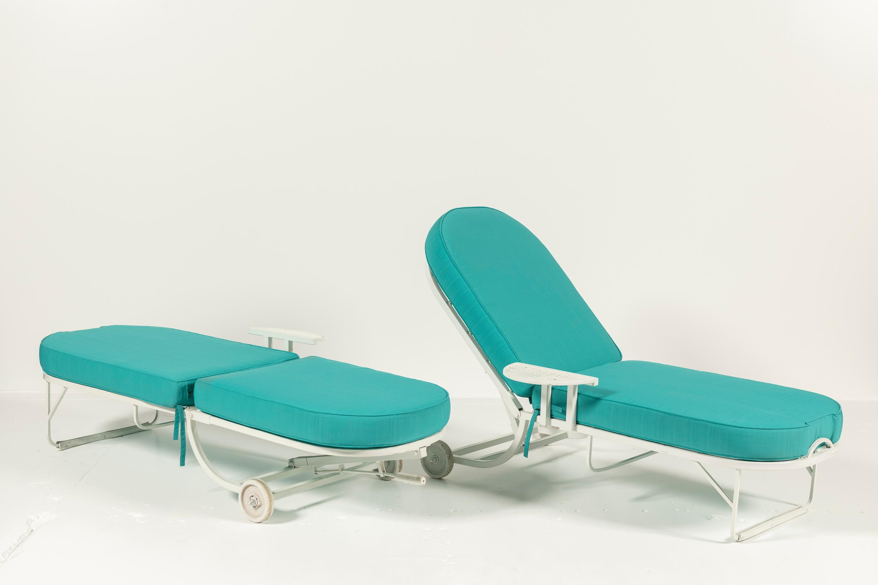 A pair of Mid-Century Modern adjustable outdoor patio recliners with an integrated side table, combining style and functionality. Crafted from durable painted metal with plush cushioned upholstery, these recliners  transition from an upright