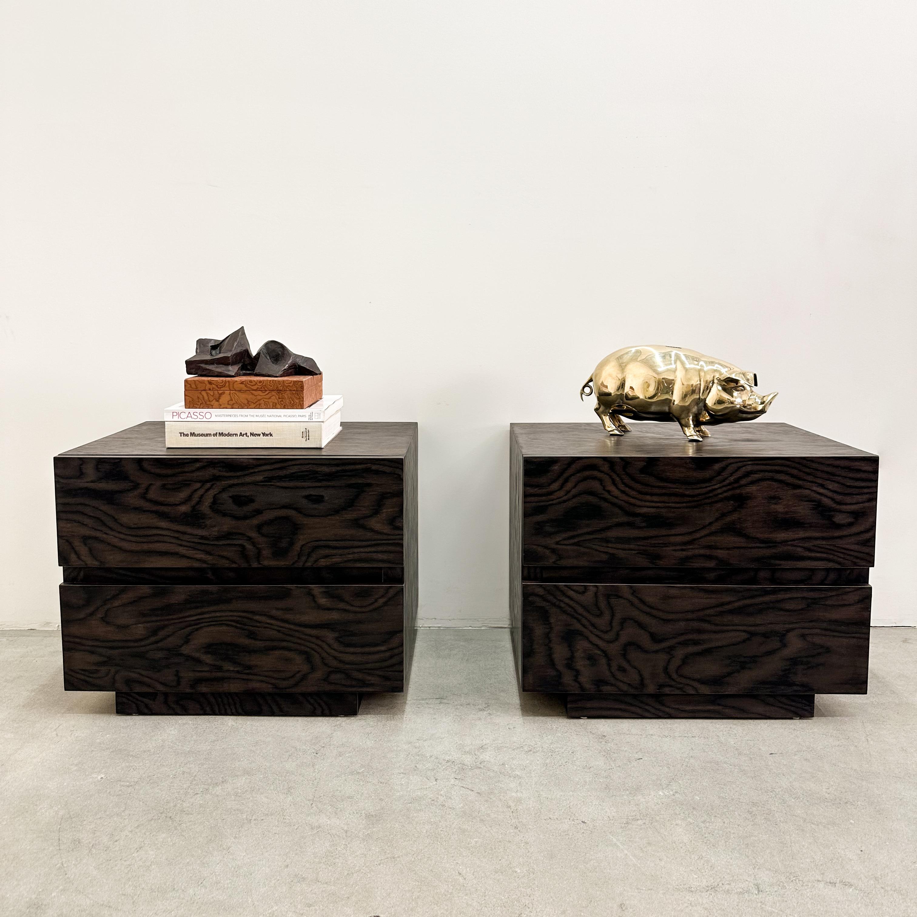 A stunning pair of mid-century modern nightstands from the 1970s, featuring a rich dark brown tone-on-tone wood grain finish. With clean lines and minimalist design, these two-drawer nightstands offer both style and functionality. The smooth-glide