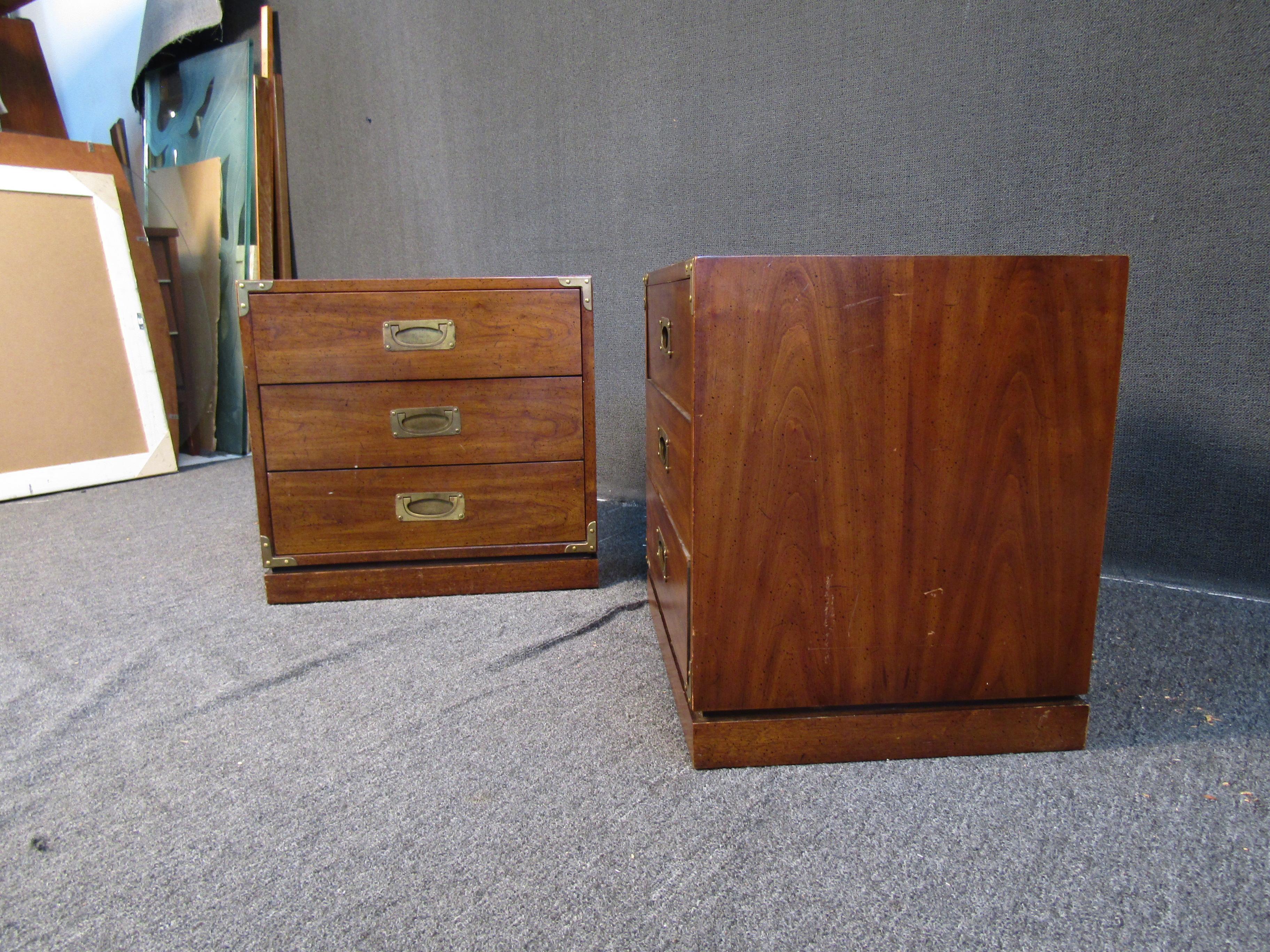 This pair of vintage Drexel Furniture campaign nightstands combine rich walnut woodgrain with brass accents to stunning effect. Three large drawers on each also allow them to aid in organization and storage for any bedroom. Please confirm item