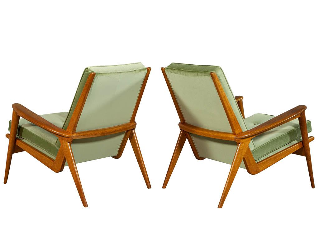 Pair of European oak midcentury lounge chairs with proprietary spring upholstery. In a natural oak finish and satin green fabric.

Price includes complimentary curb side delivery to the continental USA.