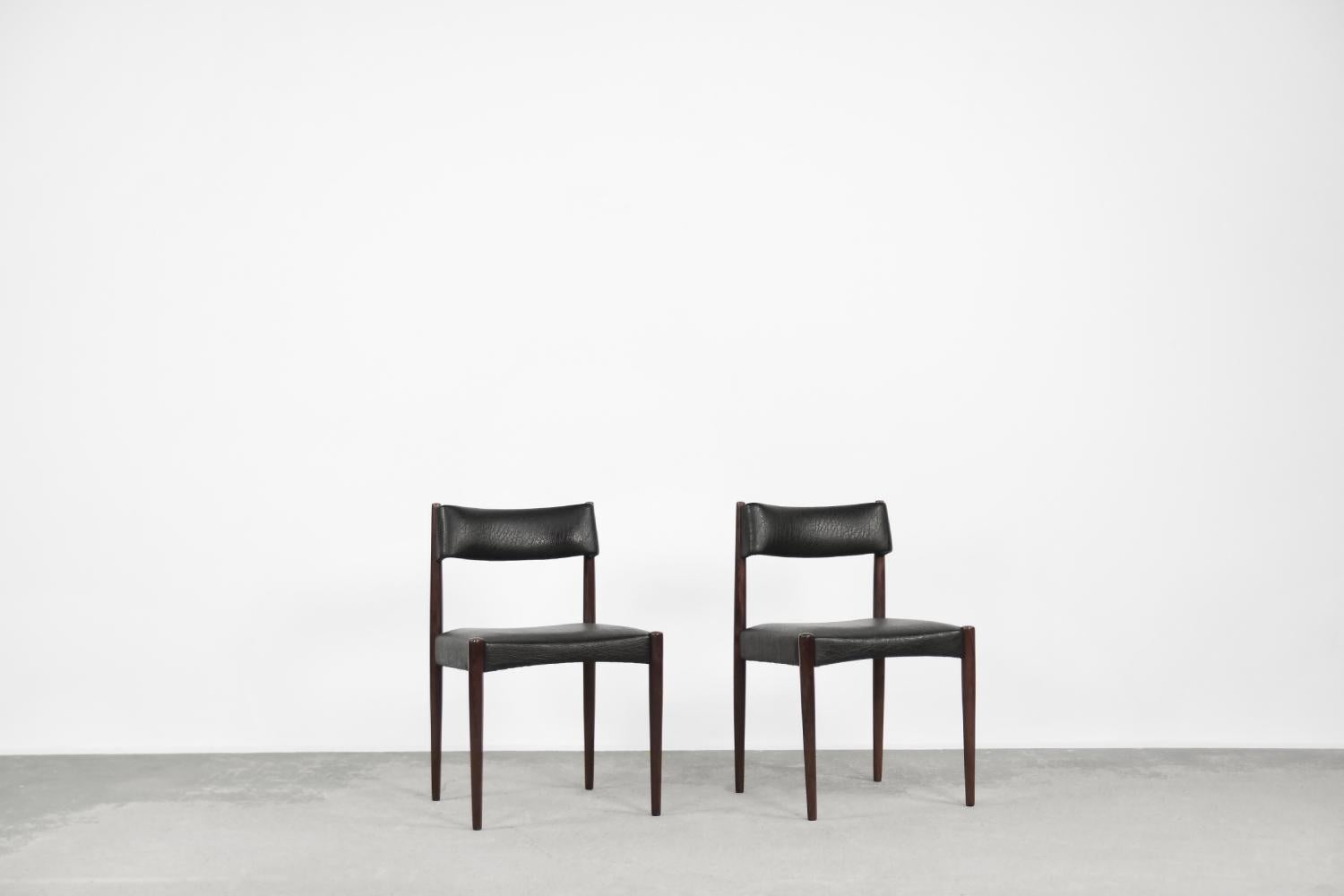 This set of two elegant dining chairs was designed by Aksel Bender Madsen for the Dutch manufacture Bovenkamp during the 1960s. Madsen is famous for its exquisite craftsmanship with organic forms of wood. This chairs are upholstered with black vinyl