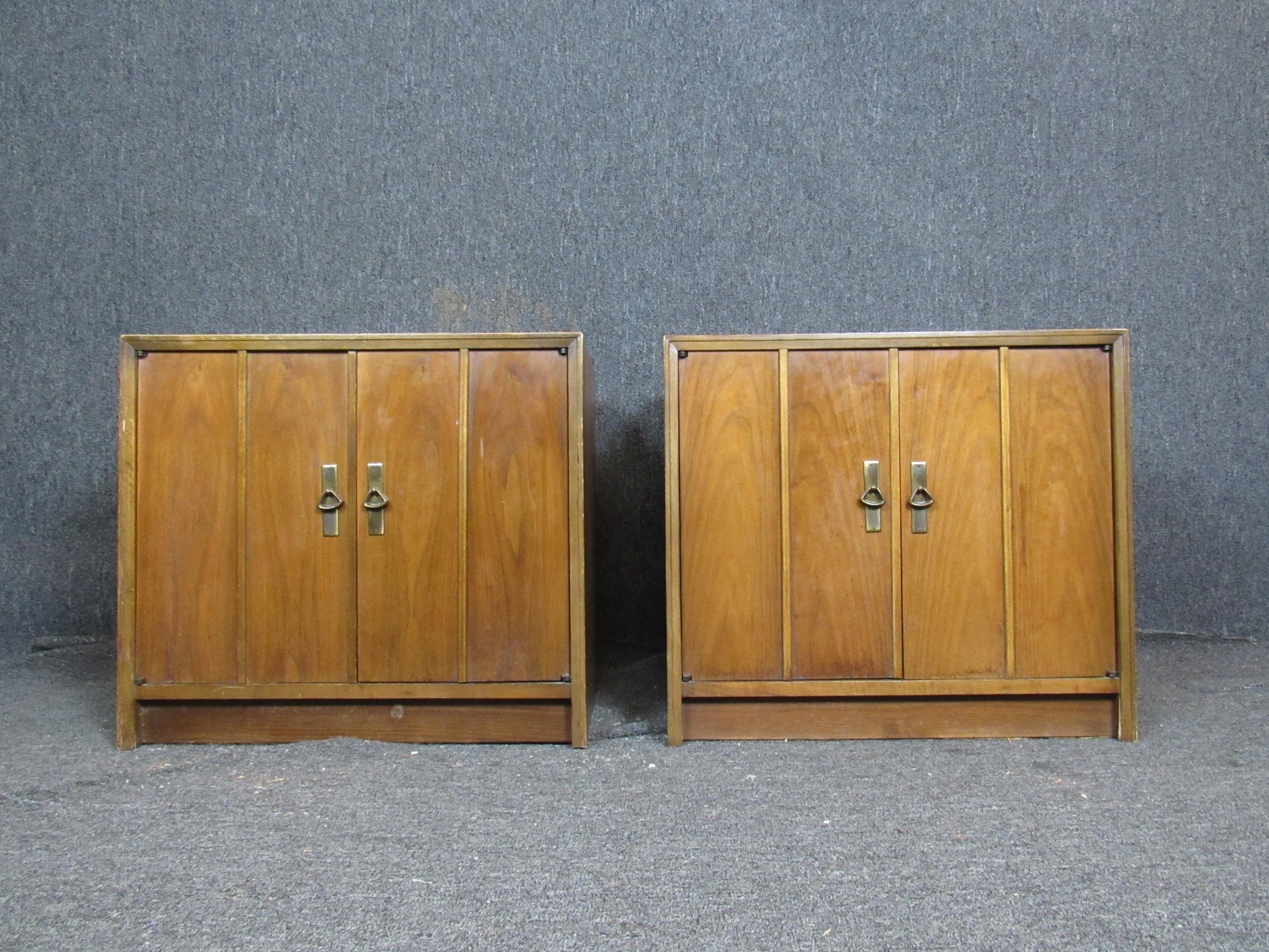 Attractive pair of Mid-Century Modern walnut night stands. Double doors on each open to reveal ample storage. Fine brass fixtures add a touch of sophistication and practicality. Refinishing available. 

Please confirm item pickup location (New