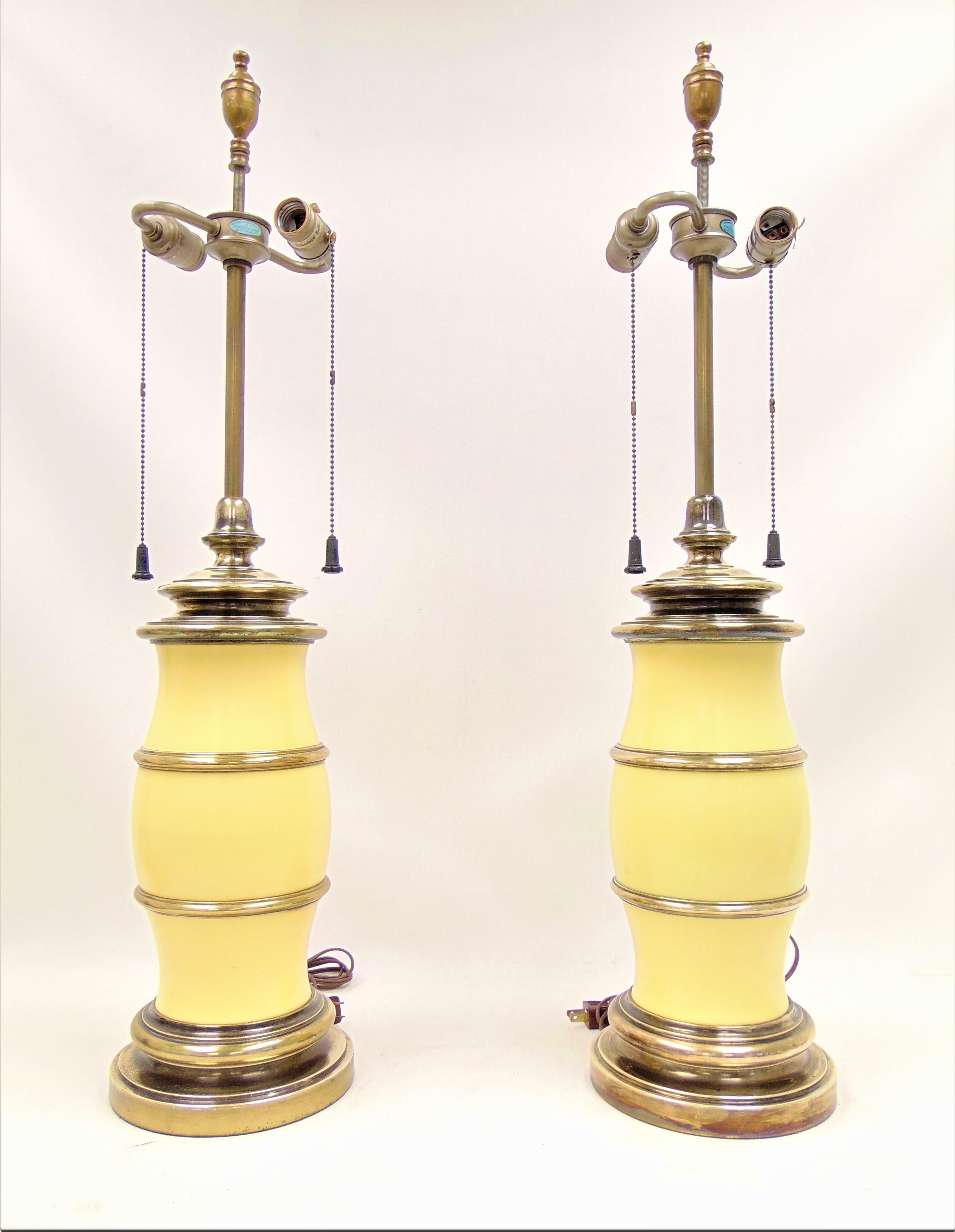 These are a pair of vintage midcentury yellow and brass lamps made by Stiffel.