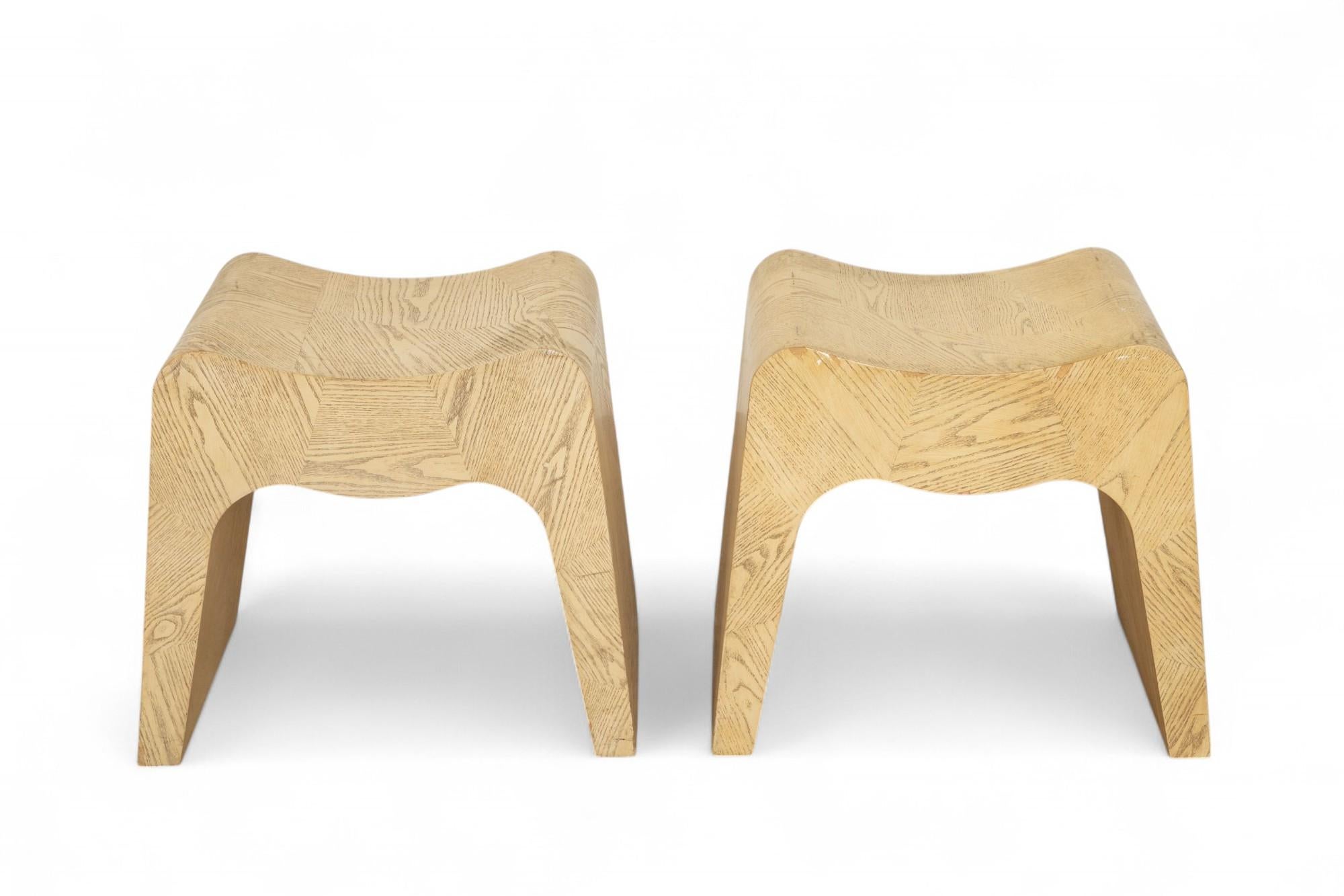 Pair of vintage minimalist cuved and cerused oak stools, USA 1980s 
A sculptural and minimalist pair of stools crafted in the United States, circa 1980. Made from solid oak, each piece features a gracefully curved seat and arched legs. Constructed