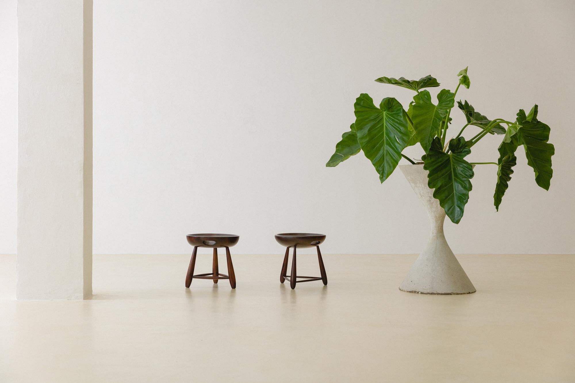 The Mocho stool is one of the most iconic pieces designed by Sergio Rodrigues in 1954, before founding the Oca store. This pair is made of gorgeous solid Rosewood in very good vintage condition. 

As a free interpretation of a typical rural