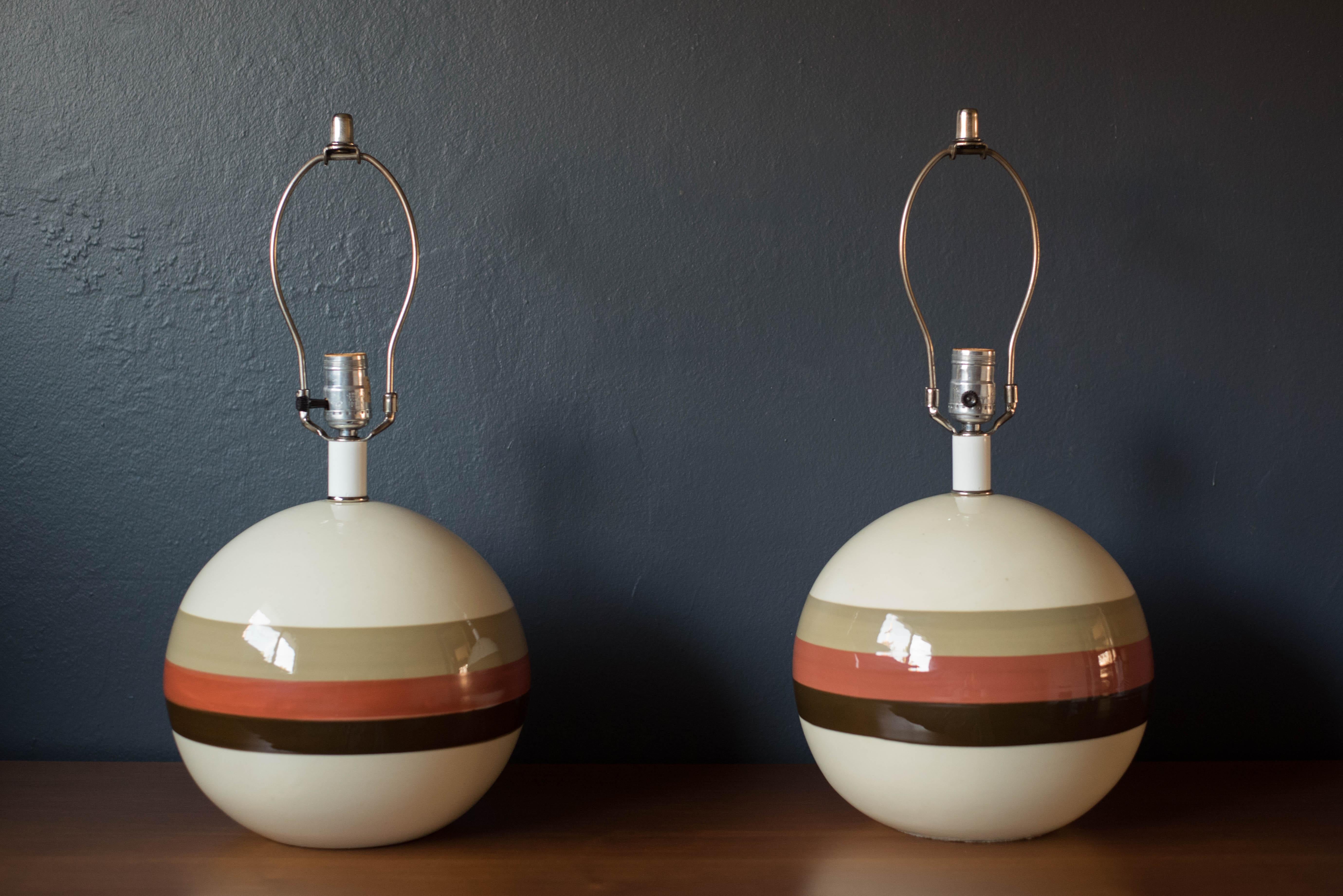 Mid century round pair of ceramic pottery lamps circa 1970's. This unique set features a natural earth tone monochromatic palette in a gloss finish. Pairs well with a drum or cone shaped shade for a mid century modern or bohemian interior style.