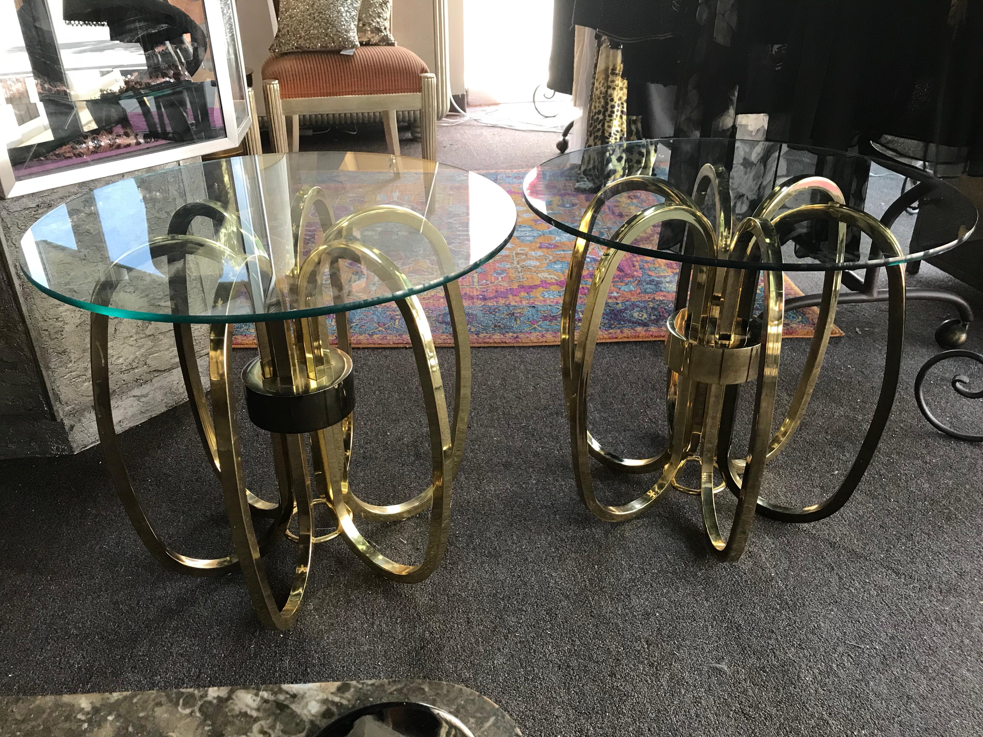 From a very upscale residence in Palm Springs, this pair of brass oval rings side tables were purchased in the early 1980s. Original glass tops.