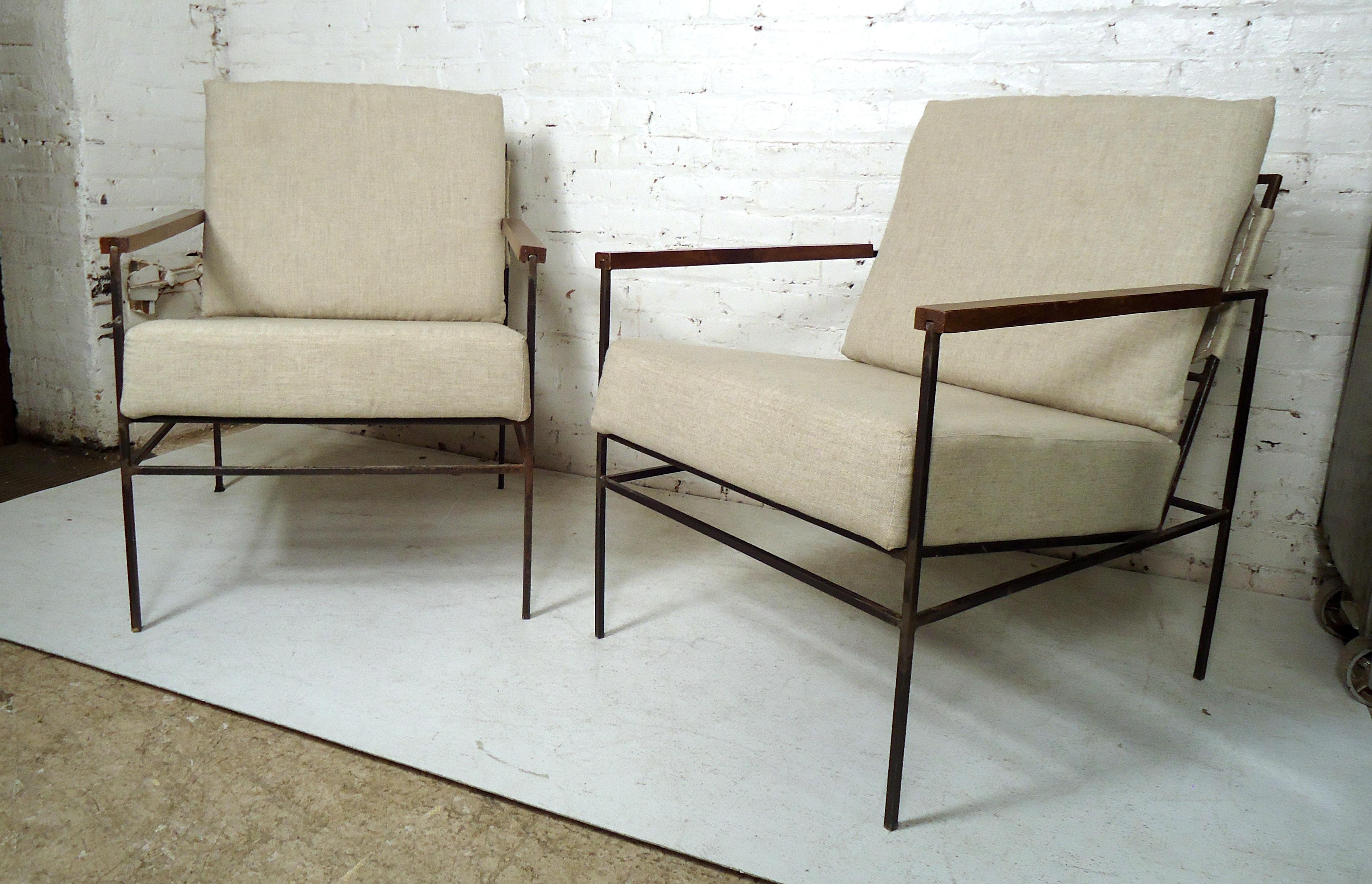 Sleek pair of vintage modern style iron frame lounge chairs feature wood armrests, upholstered seat and cushion.

(Please confirm item location NY or NJ with dealer).
