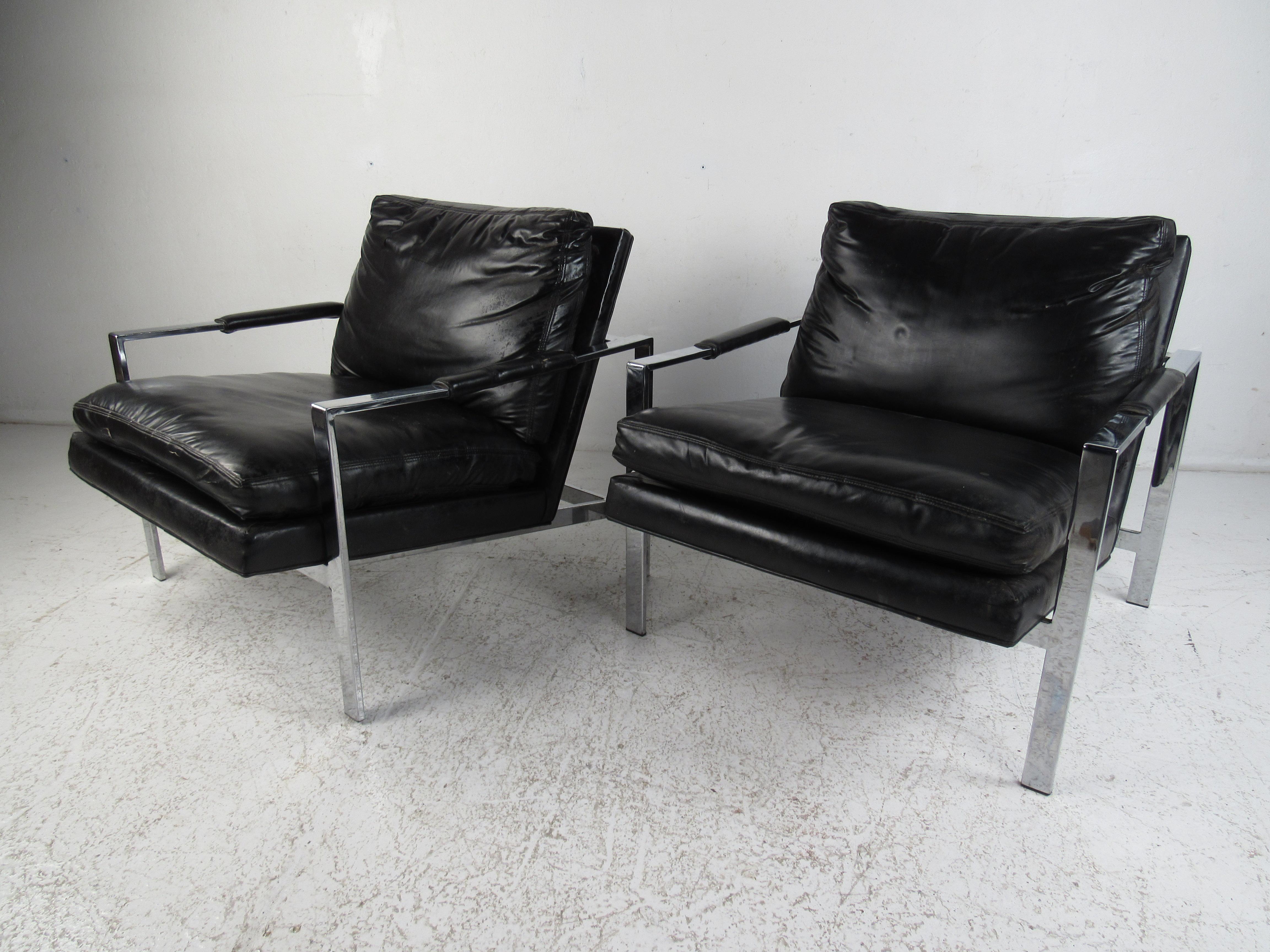 This stunning pair of Mid-Century Modern lounge chairs feature a flat bar chrome frame with overstuffed seating covered in black vinyl. An iconic design by Milo Baughman with the original tag underneath. This sleek and comfortable pair of lounge