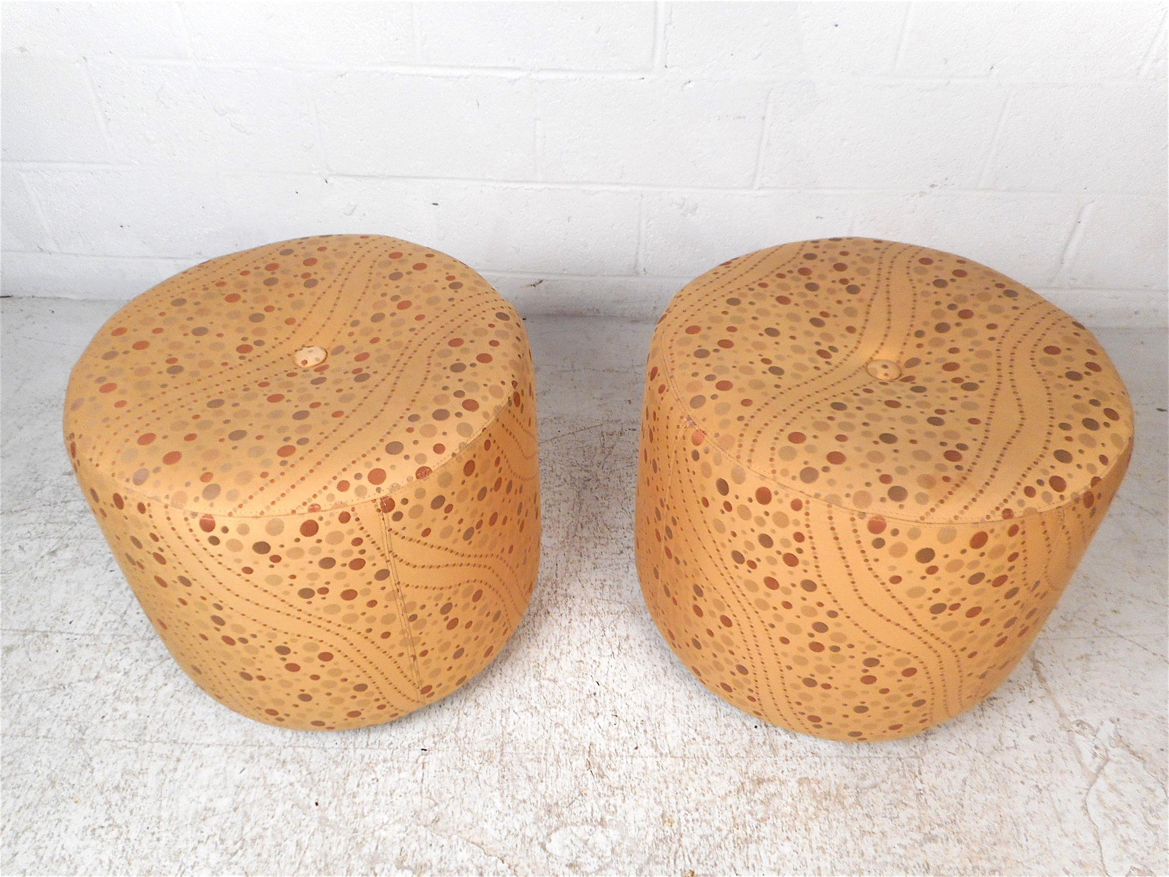 Paire élégante d'ottomans/tabourets à pieds modernes. Revêtement vintage au design intéressant, avec une touffe au centre de l'assise. 4 roulettes en dessous permettent à ces poufs d'être facilement manoeuvrés. Cette paire est sûre de s'avérer un