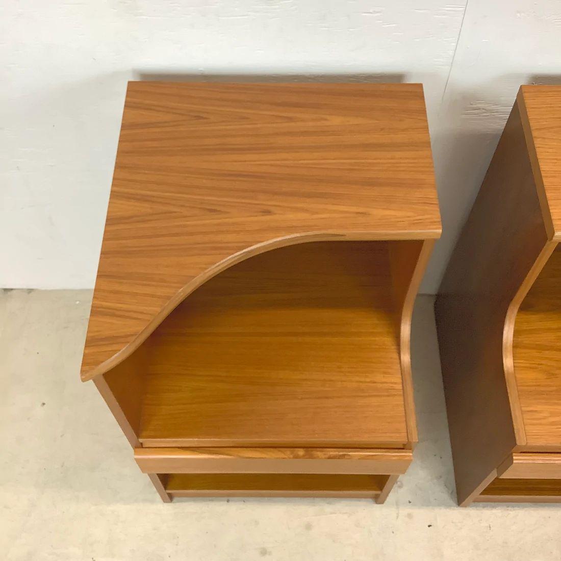 This impressive and large scale pair of teak bedside tables feature two tier design, spacious drawer, and open lower cabinet. The perfect pair of Scandinavian Modern style nightstands to add in any setting.

Dimensions: 18.5 W x 20.25 D x 29