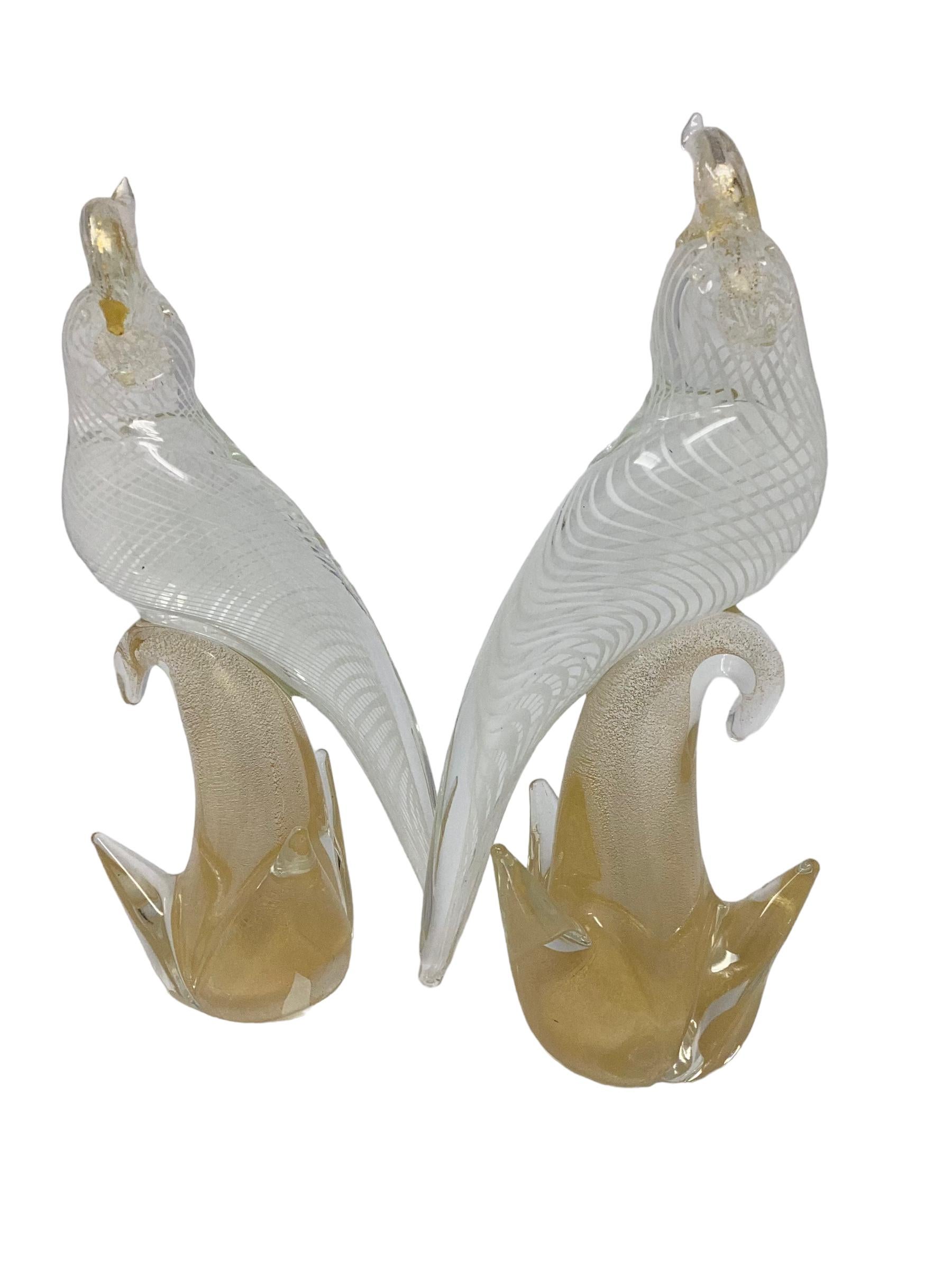 Pair of Vintage Murano Glass Birds. These birds are in the style of Archimede Seguso who was known for his animal sculptures. The ribbon decorated birds are delicately perched on a gold infused branch. Both are in excellent vintage condition.