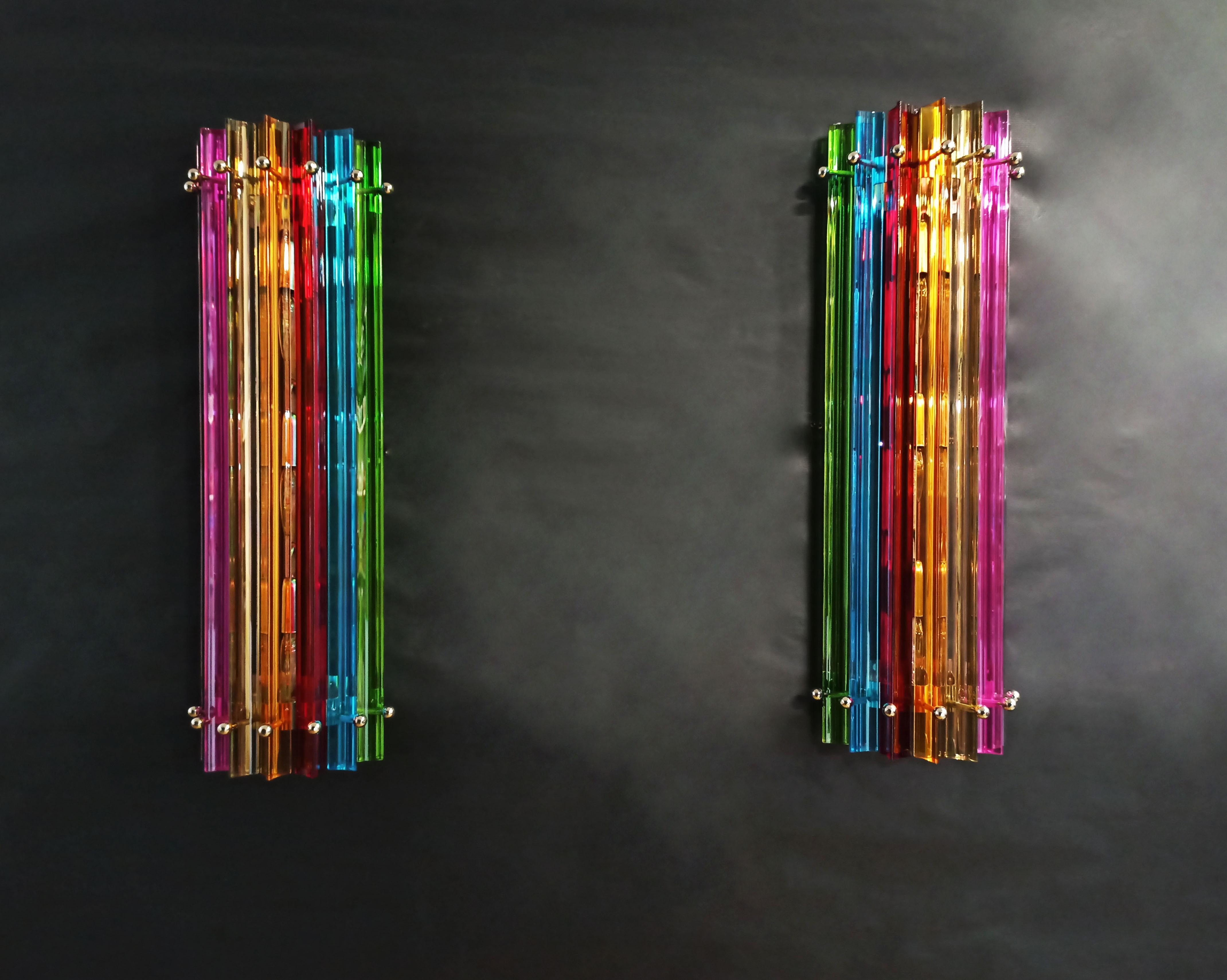 Fantastic pair of vintage Murano wall sconce made by 7 Murano crystal prism (triedri) for each applique in a chrome metal frame. The shape of this sconce is column. The glasses are transparent, blue, amber, green, and pink. The wall lamps can be