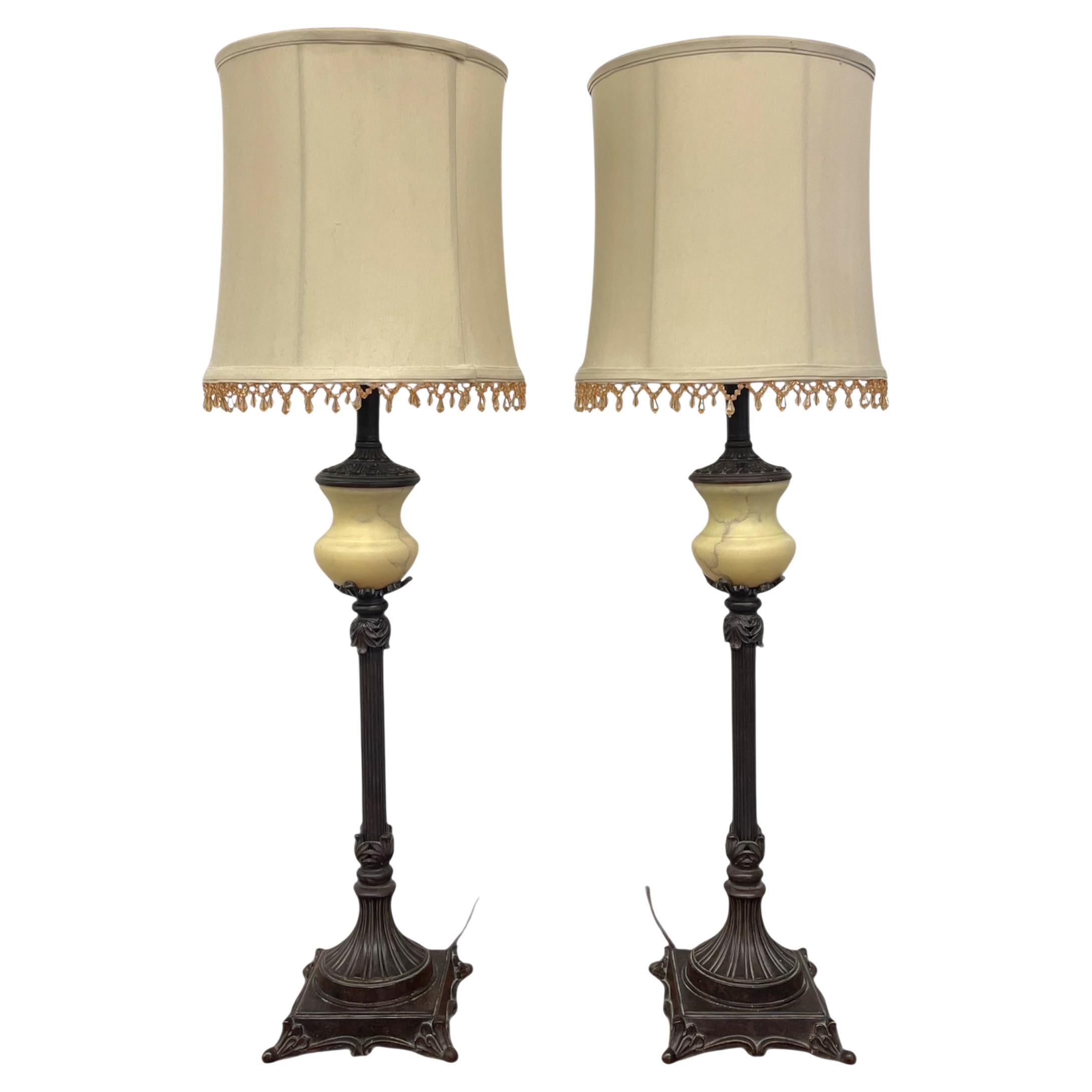 Paire de lampes de table vintage néoclassique avec base en métal ornée et abat-jour en tissu.