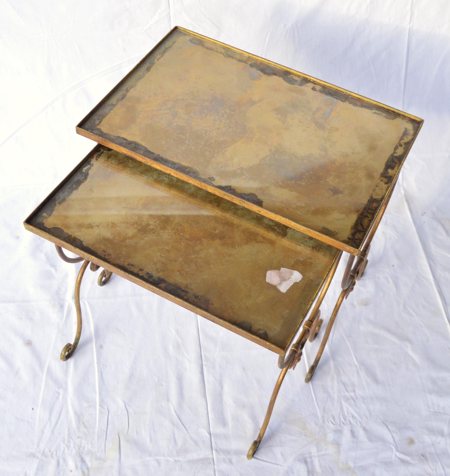 Pair of vintage nesting metal mounted tables with oxidized glass top.
Dimensions: 52x34, height - 48 cm.
Condition report: Oxidation exfoliation resulting transparent white spots in several places.