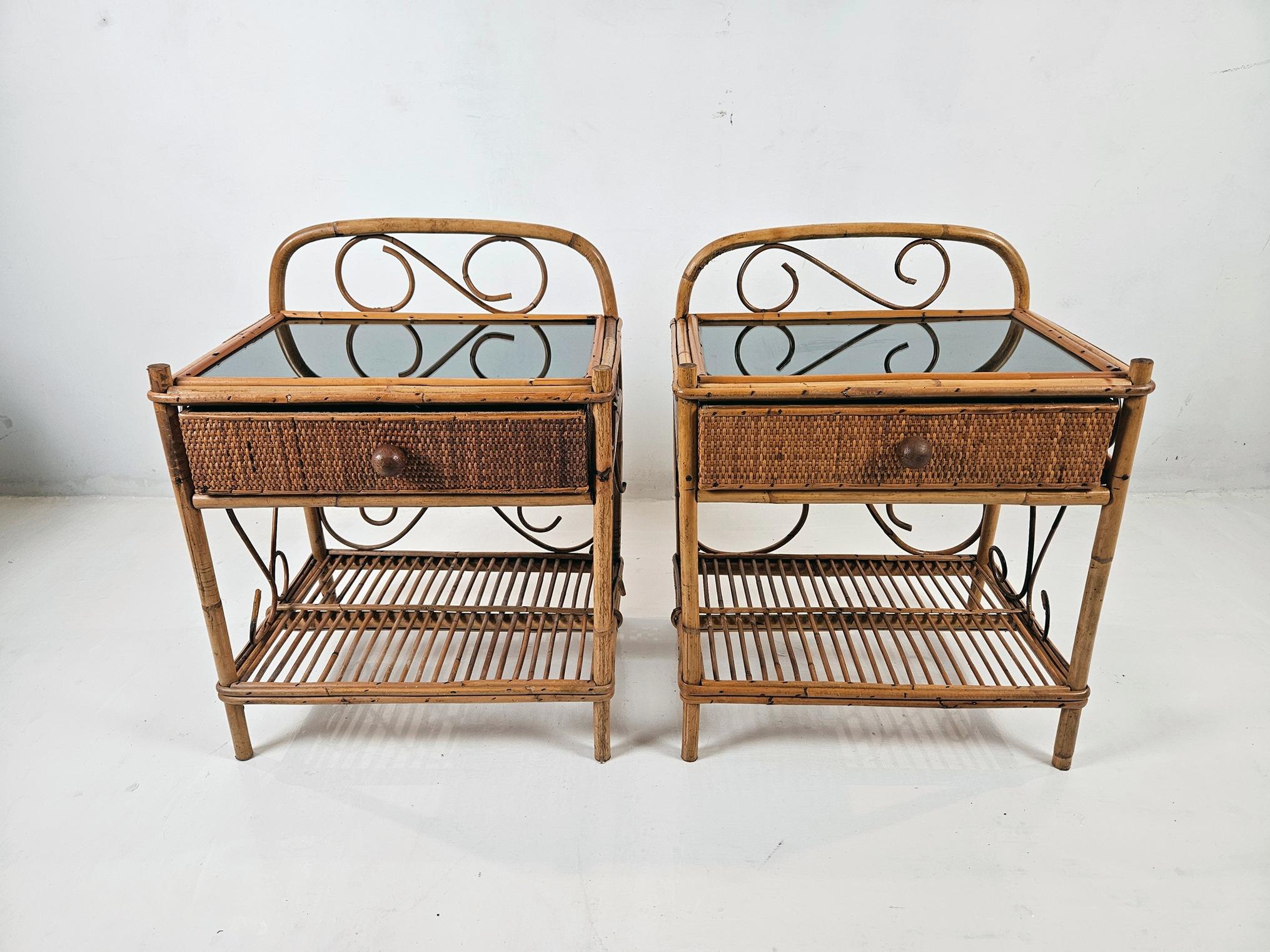Un par de elegantes y estilizadas mesillas de noche hechas a mano en bambú. Cada soporte tiene un cajón en la parte superior y un estante en la inferior.