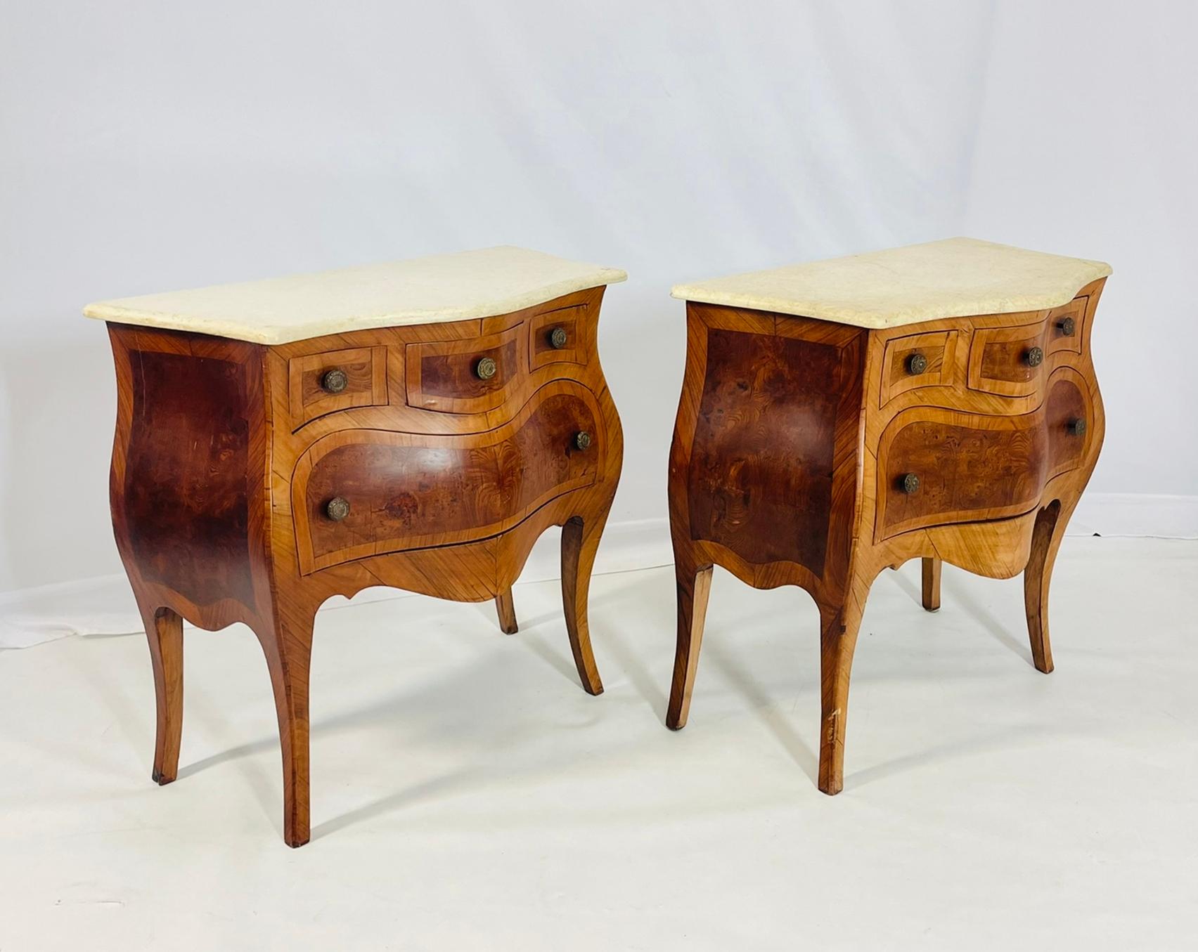 Realza la decoración de tu hogar con este exquisito par de cómodas Bombay vintage de madera de olivo procedentes de Italia, de principios del siglo XX. Elaboradas con precisión y atención al detalle, estas cómodas antiguas presentan una