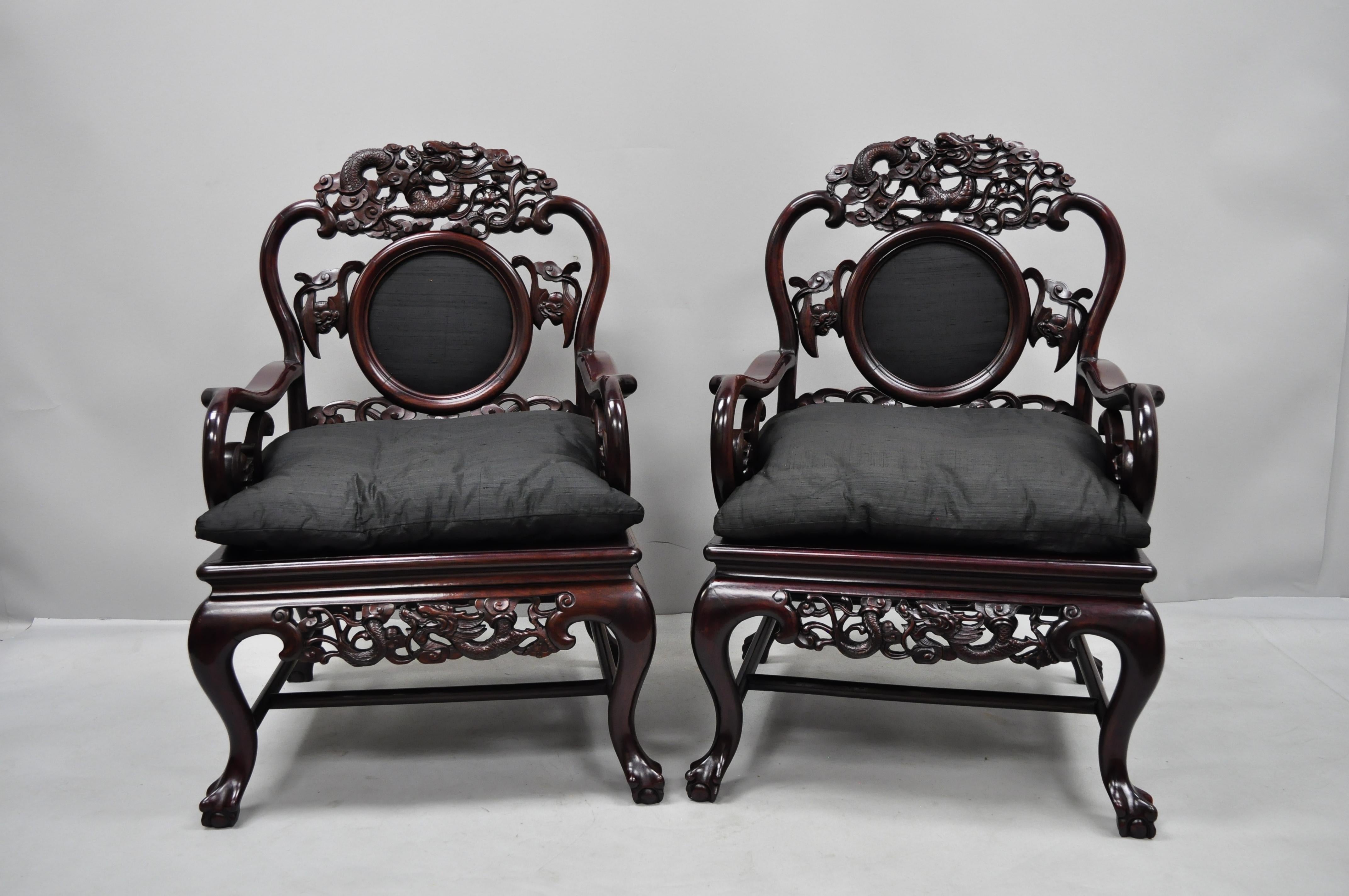 Pair of vintage oriental dragon carved rosewood lounge throne armchairs. Items feature upholstered backrest and loose cushions, dragon carved top rail and lower rail, solid heavy wood construction, circa late 20th century. Measurements: 37