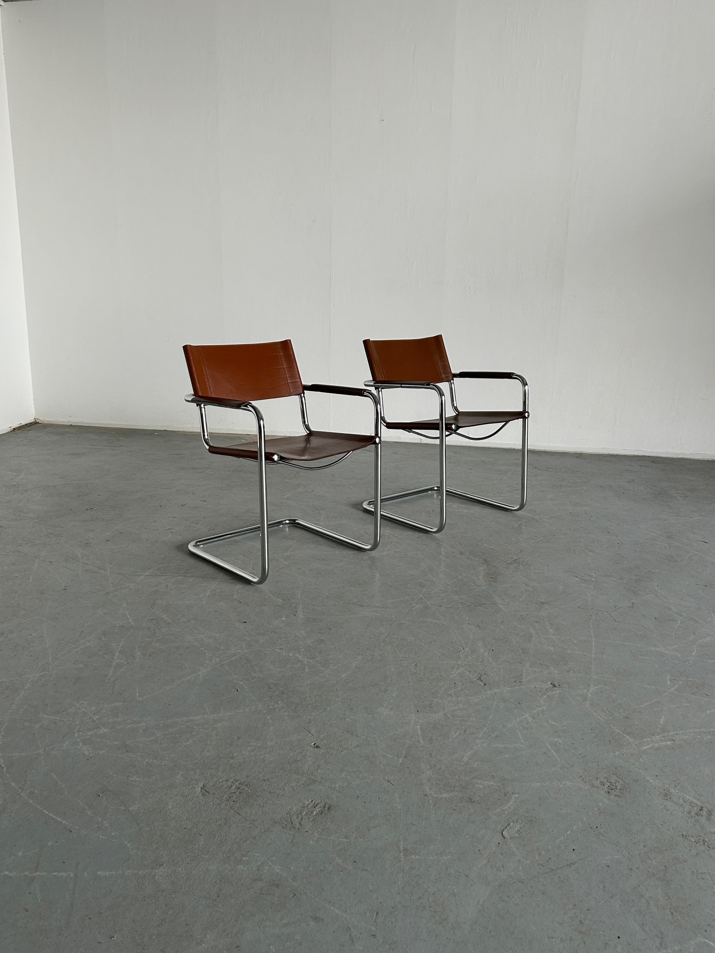 Set of two cantilevered armchairs designed by Centro Studi architects for Matteo Grassi.
Based on the iconic Bauhaus design by Mart Stam and Marcel Breuer.
Tubular chromed steel and brown cognac leather.
Leather back embossed with 