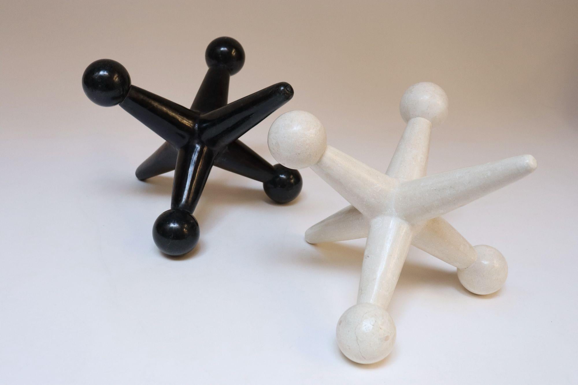 Set di due sculture di jax/jacks in stile Hollywood Regency composte da pietre tessellate - una nera e una beige, realizzate per la Marquis Collection of Beverly Hills (Filippine, circa fine anni '80/inizio anni '90).
I fanti, oggetti decorativi