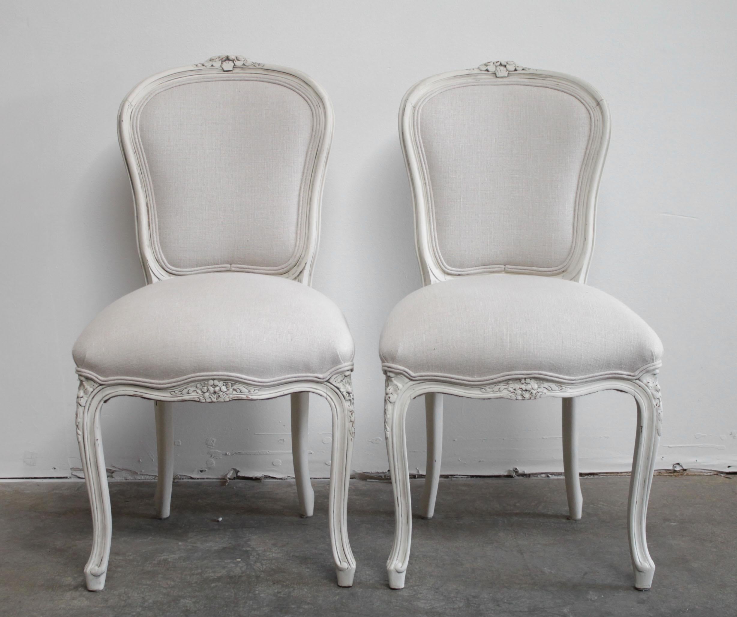 Pair of vintage painted and Upholstered French side chairs in the Louis XV style.
Painted in a soft oyster antique white, with subtle distressed edges, and reupholstered in a 100% pure organic natural Belgian linen. These are perfect dining or desk