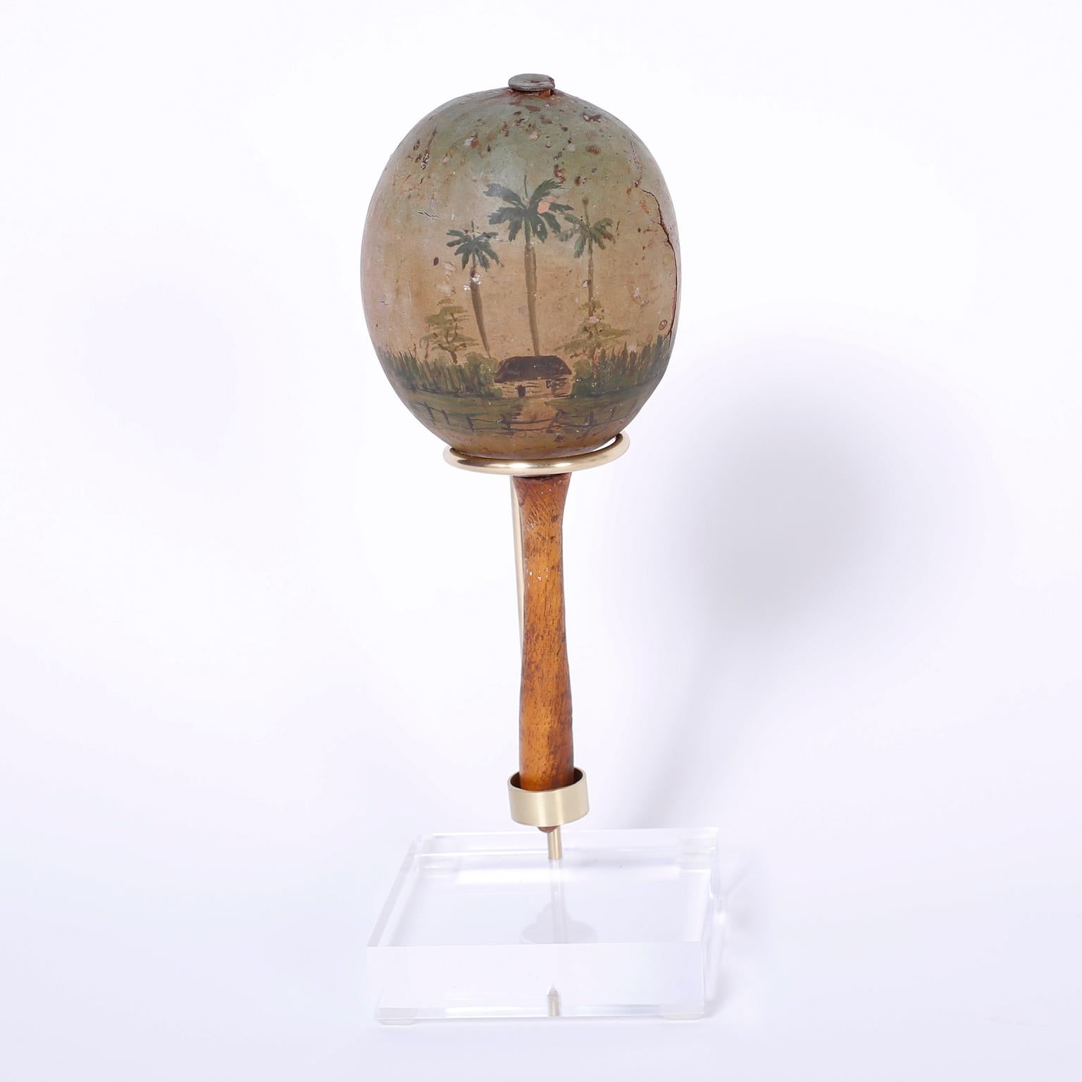 Made from gourds filled with seeds the maraca originally used in healing ceremonies became an integral part of Caribbean and Latin music. Here is a vintage pair of Cuban maracas decorated with folky palm tree sprinkled tropical scenes now perfectly