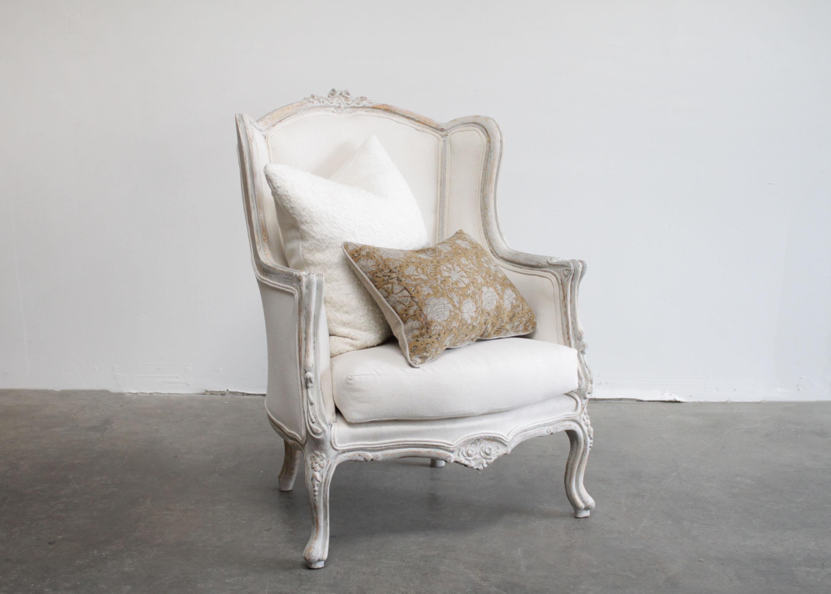 Pair of painted French style wing back bergere chairs
Vintage wing backs have been painted in a soft oyster white with distressed edges, and gilt peeking through.
Upholstered in a canvas duck cloth and finished with a double welt trim. A standard