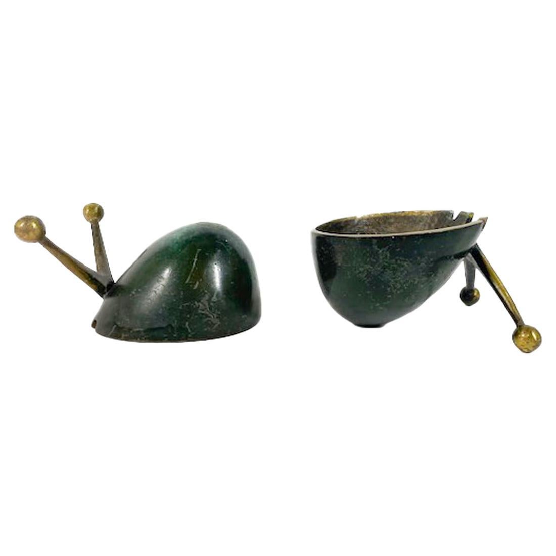 Paire de cendriers vintage en bronze moulé patiné en forme d'escargots stylisés avec antennes polies qui, lorsqu'ils sont tournés, deviennent des supports pour la coquille en forme de bol. L'intérieur de la coupe a une surface martelée avec